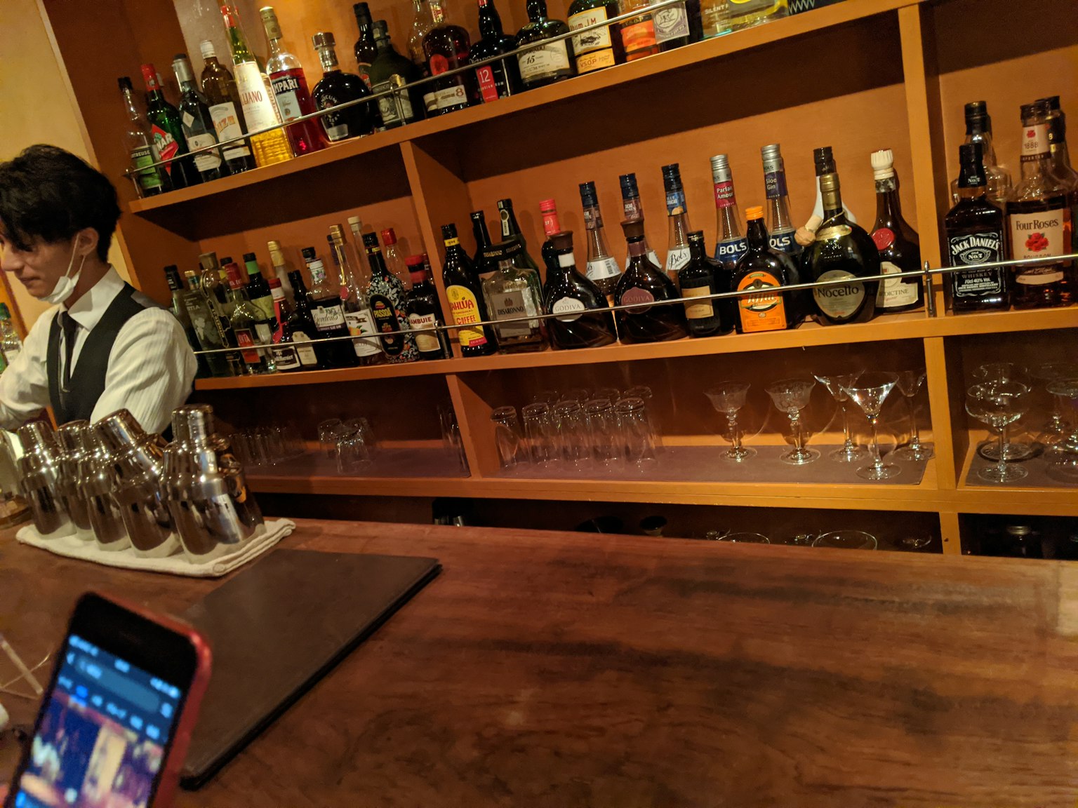 Barkeeper, der Cocktails an einer Bar mit verschiedenen Spirituosen zubereitet