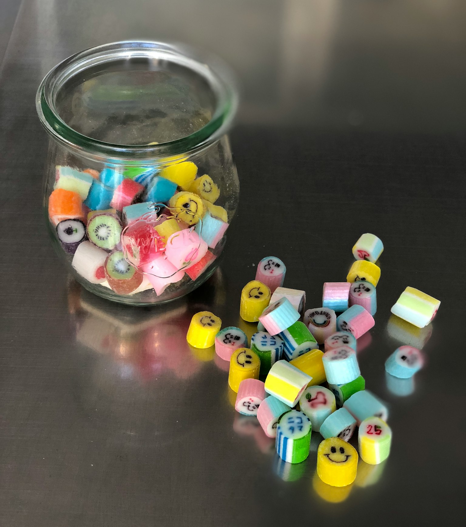 玻璃罐中的彩色糖果和周围散落的糖果