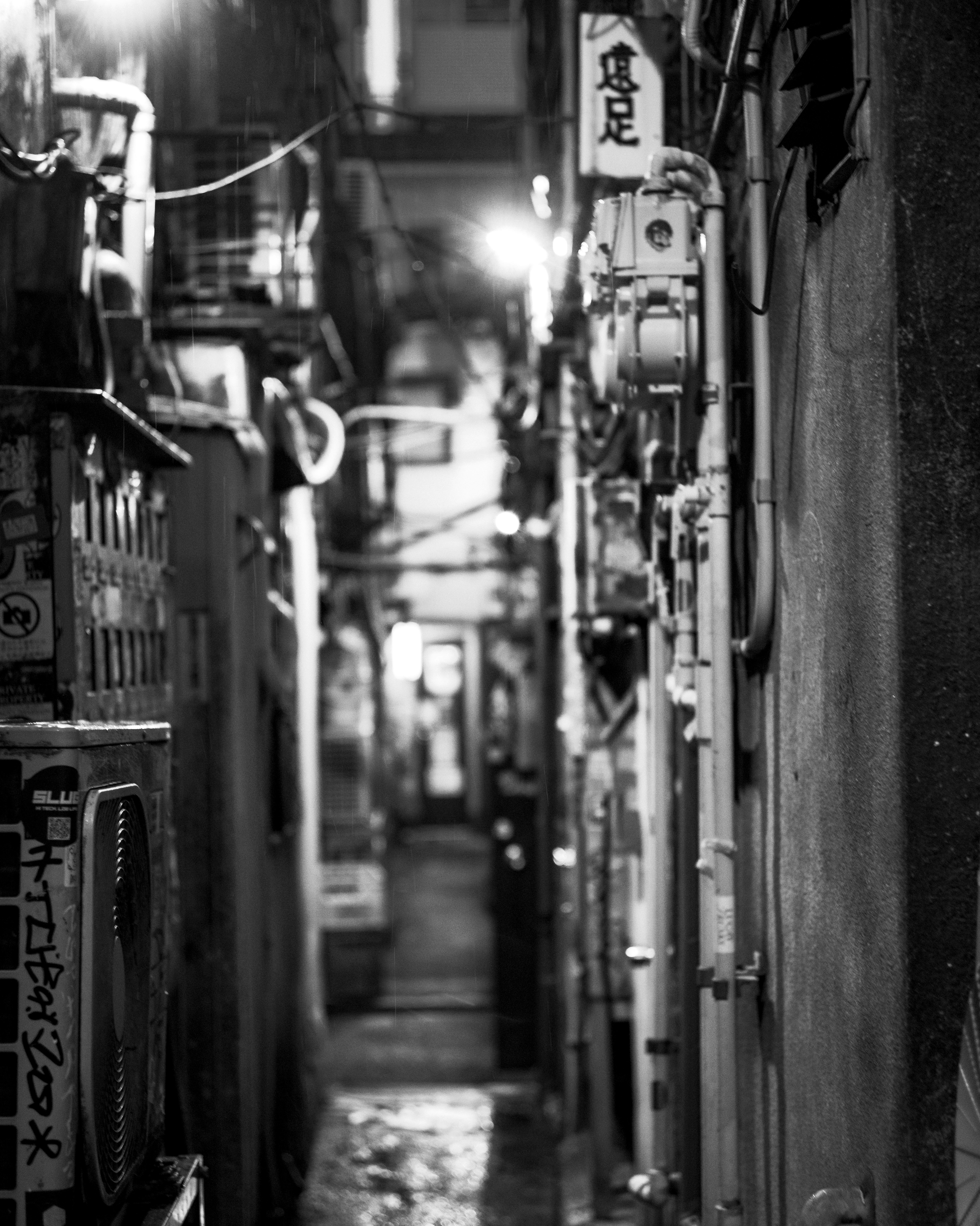 路地に並ぶ自転車と店先の看板が並ぶ夜の街並み