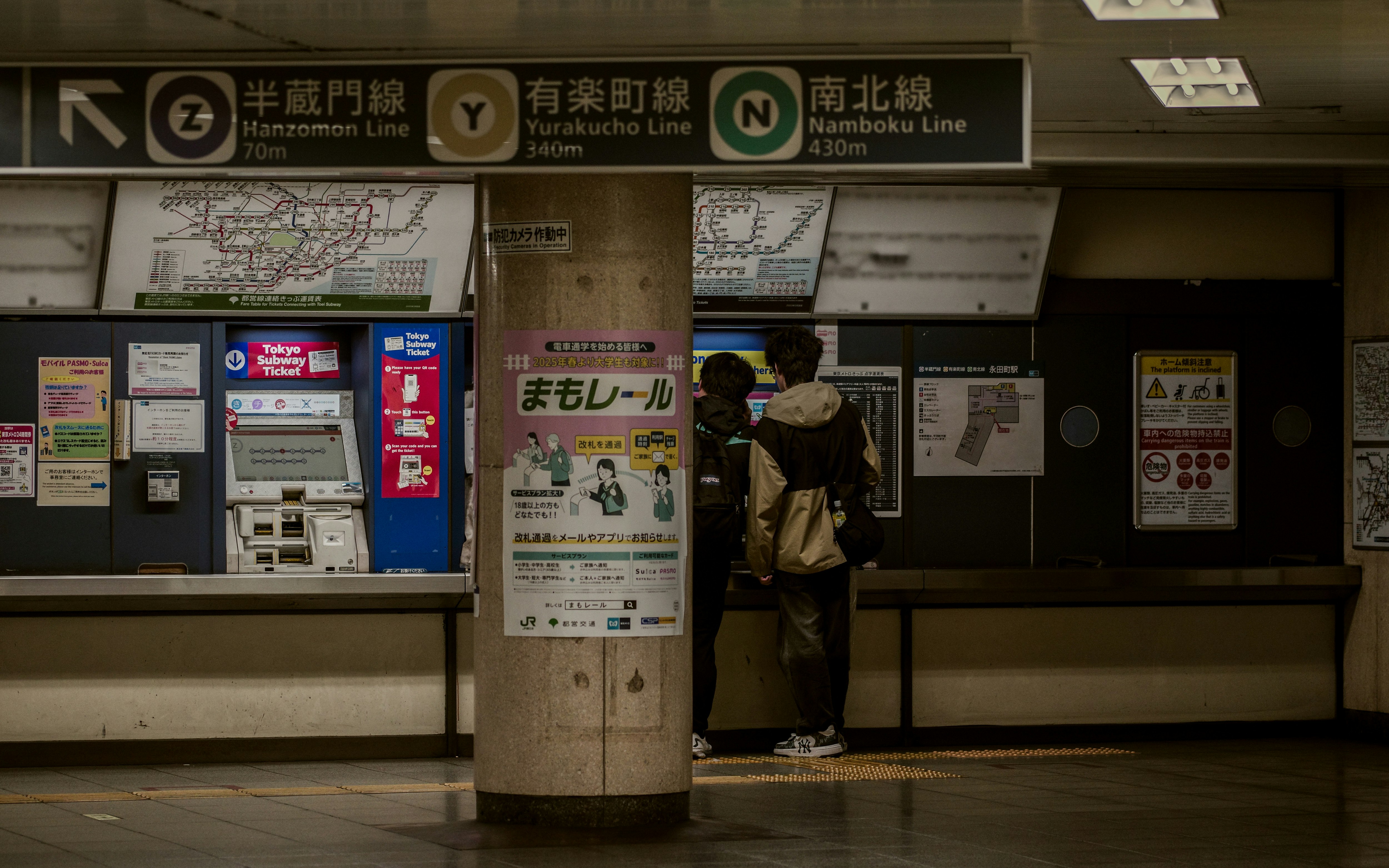 東京の駅構内で切符売り場の前に立つ観光客