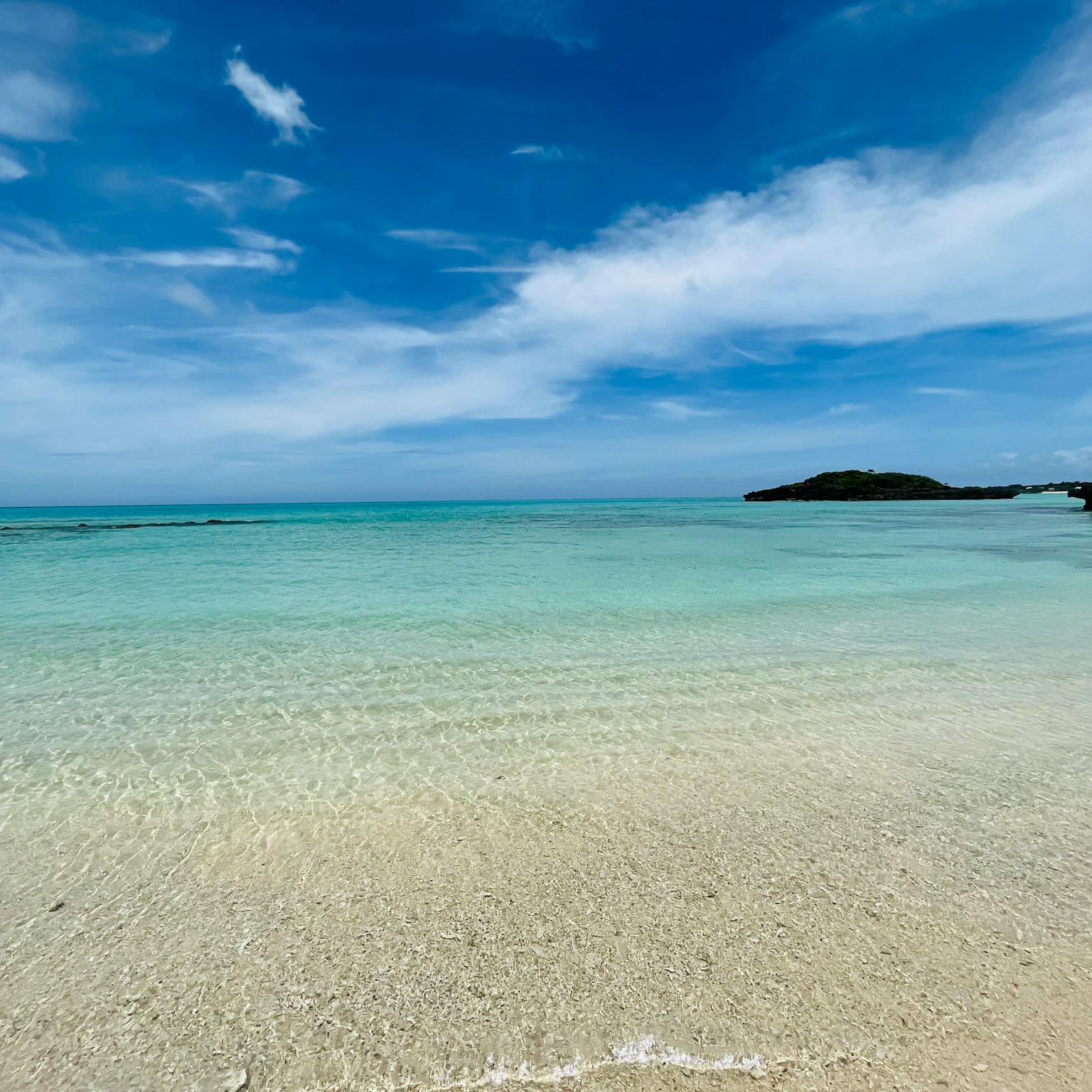 ชายหาดที่สวยงามมีทะเลสีฟ้าและชายหาดสีขาว