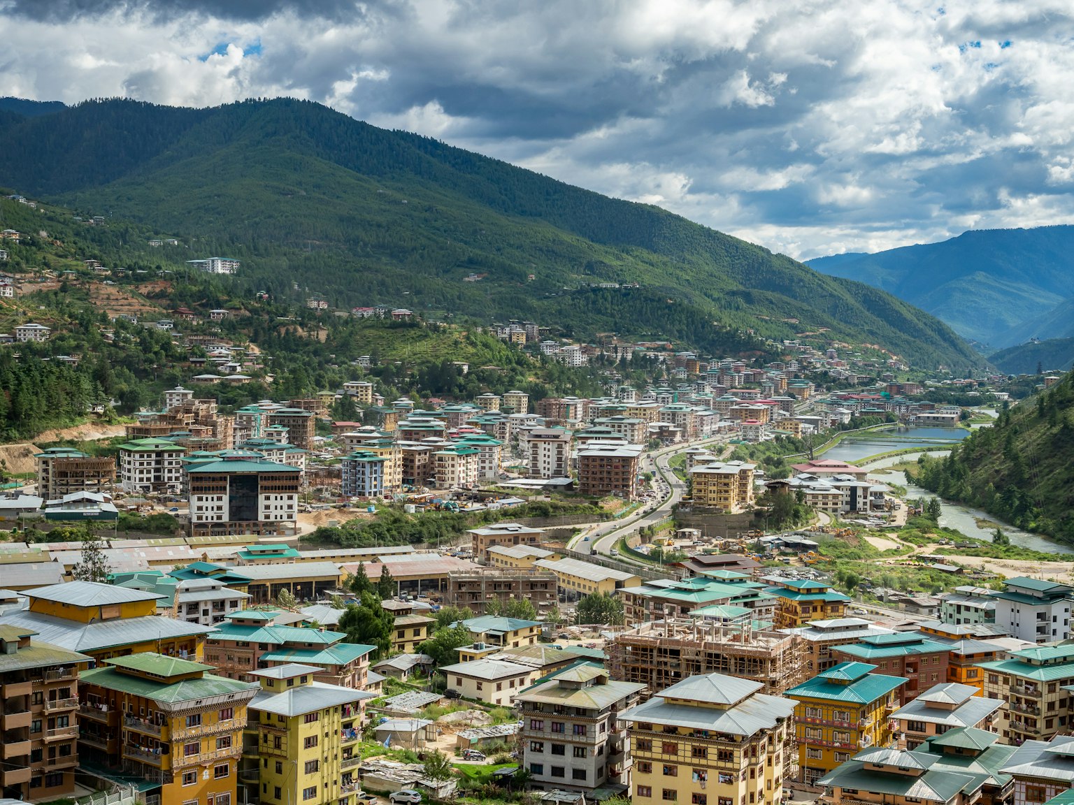 Une vue pittoresque d'une ville bhoutanaise entourée de belles montagnes avec des bâtiments et des routes