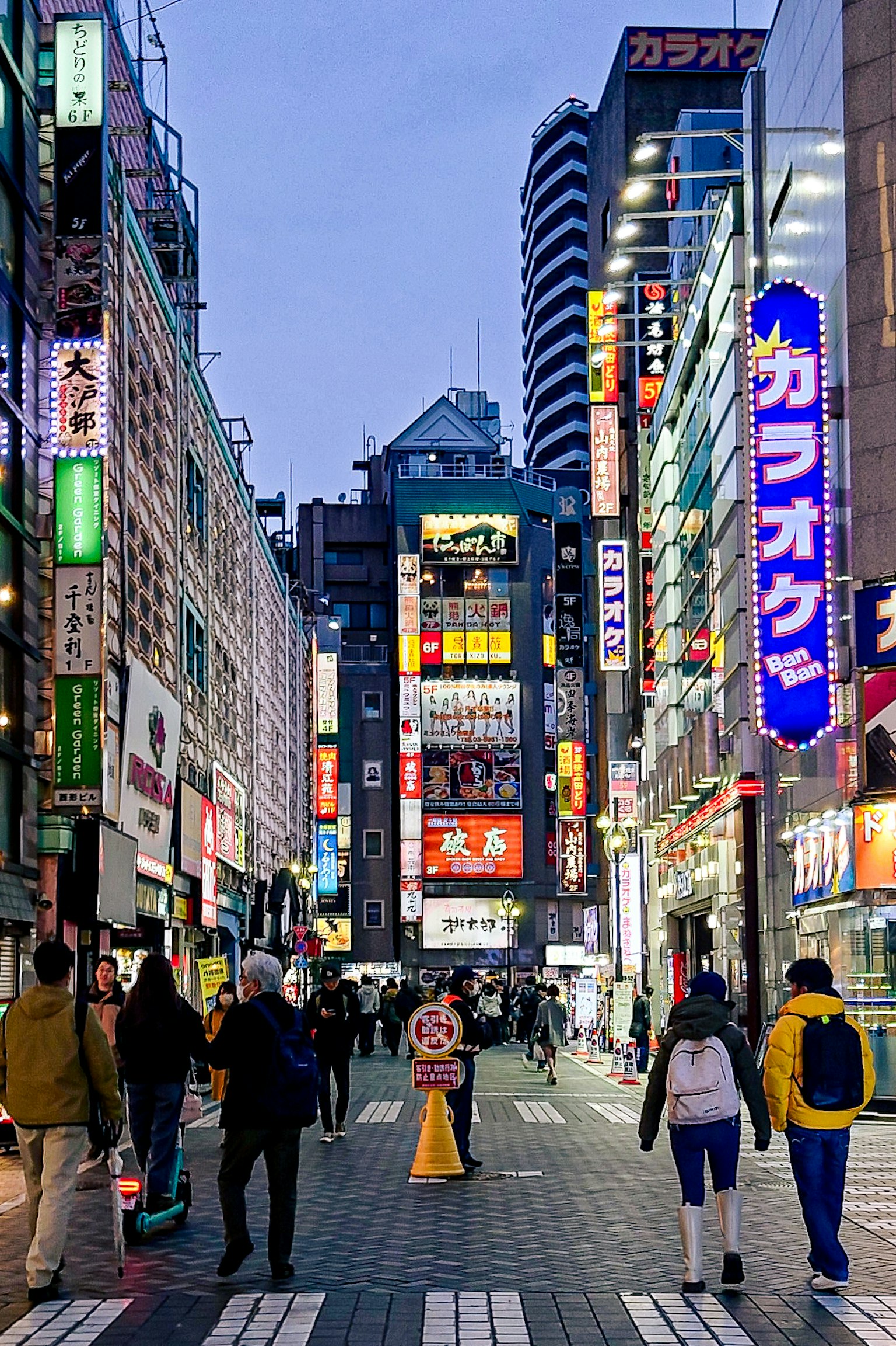 夜晚繁忙的街道場景，有人走動和明亮的霓虹燈
