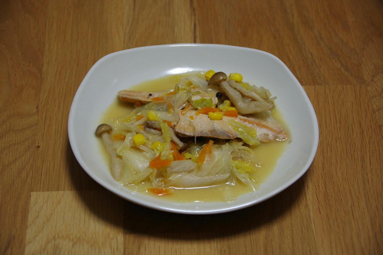 Un plat de poulet et de légumes dans un bouillon servi dans un bol blanc