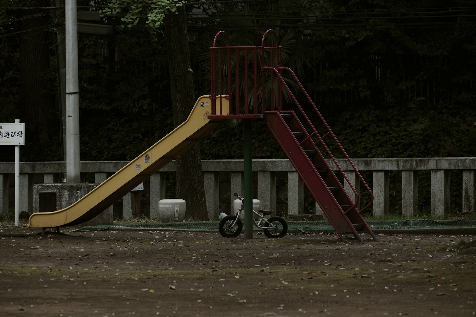 Scivolo del parco con una piccola bicicletta nelle vicinanze