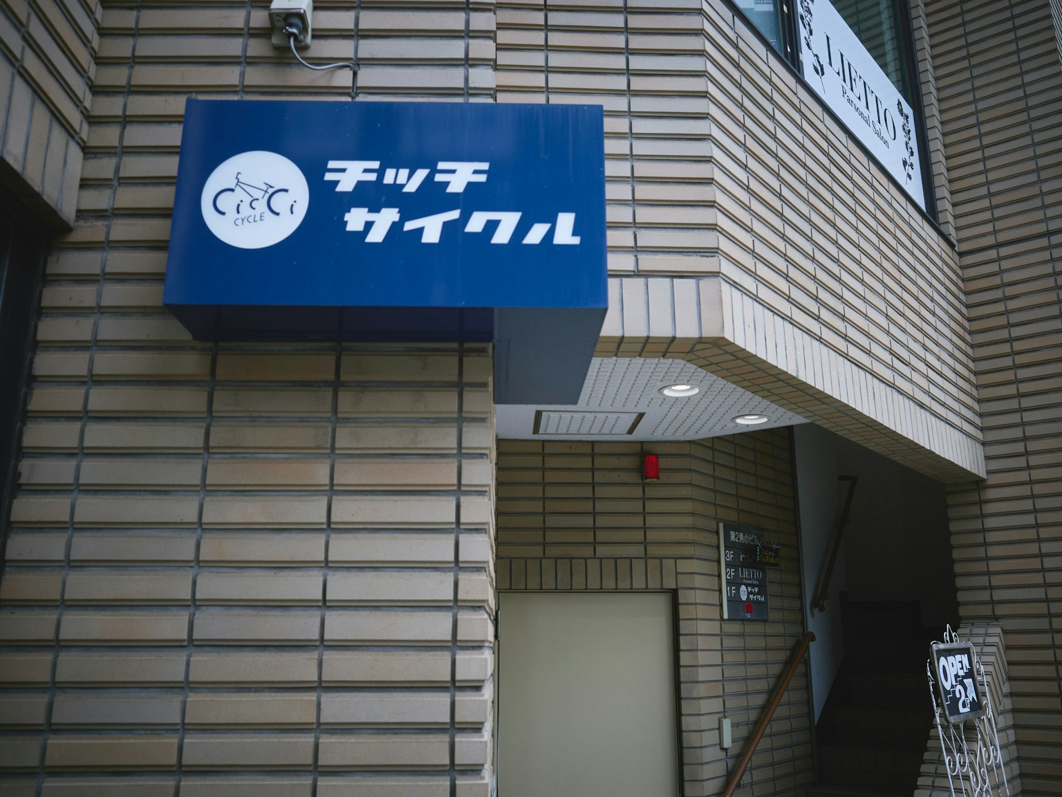 파란색 간판과 흰색 로고 및 텍스트가 있는 건물 외관