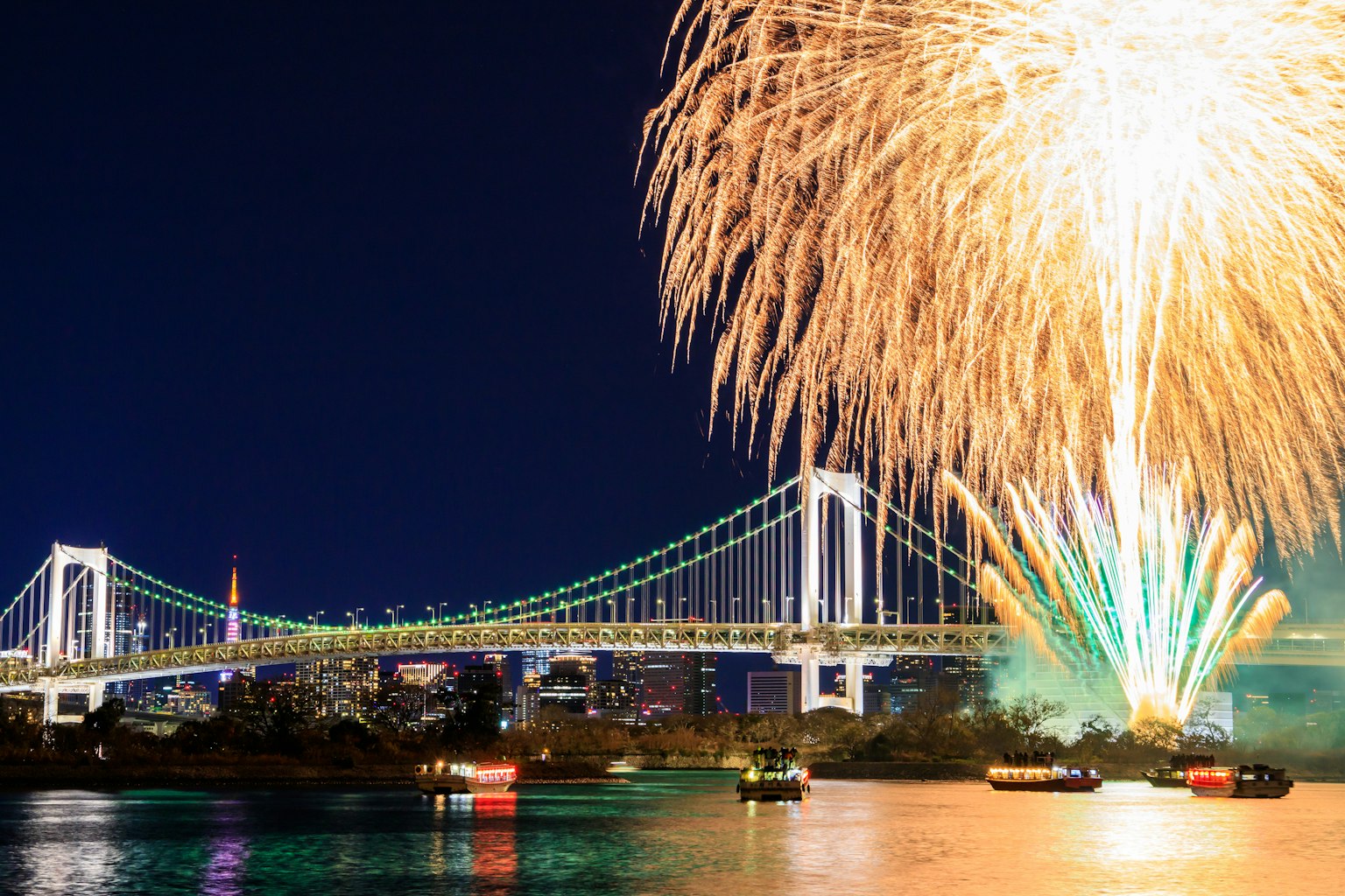 Stunning contrast of Rainbow Bridge at night with vibrant fireworks
