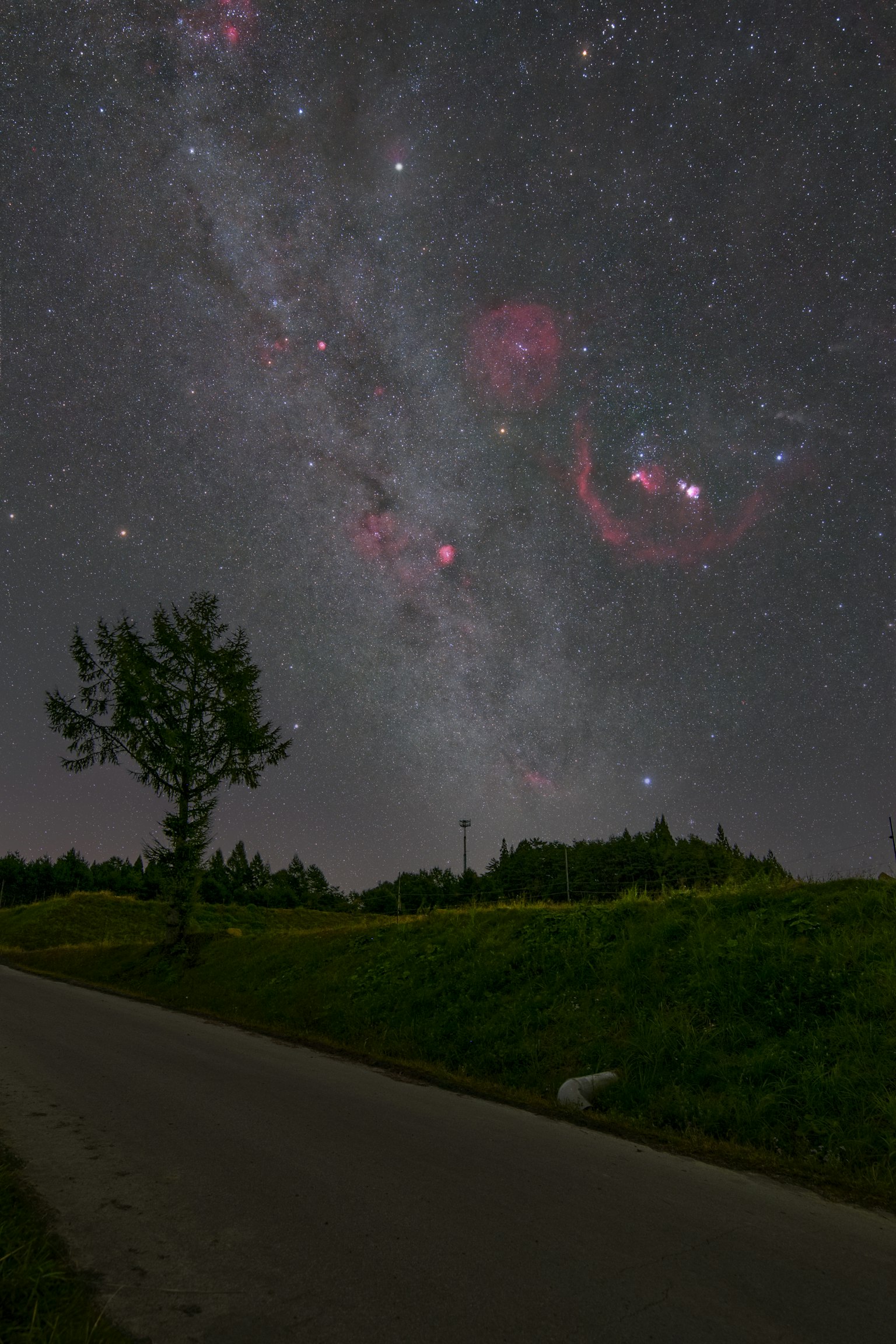 Pemandangan menakjubkan Galaksi Bima Sakti dengan nebula merah di langit malam