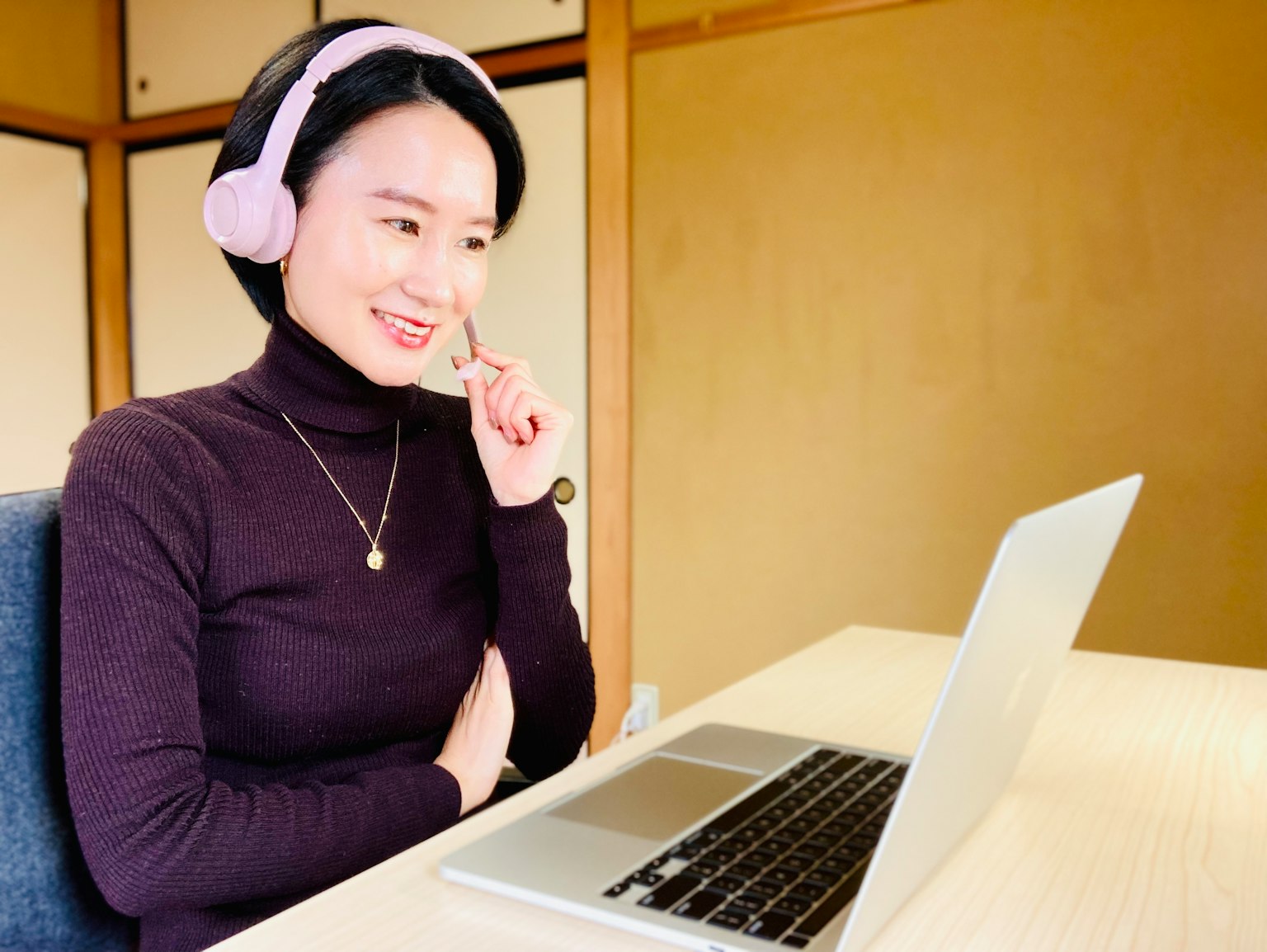 Giovane donna con cuffie che sorride a un laptop