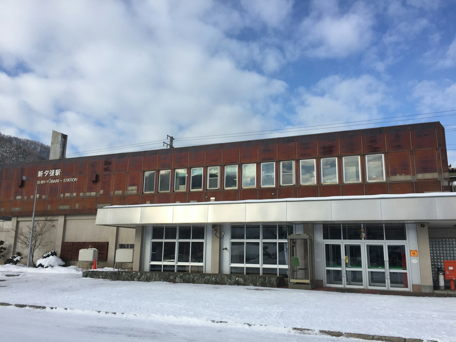 Altes Gebäude, das mit Schnee bedeckt ist, mit rostigem Außenbereich und großen Fenstern