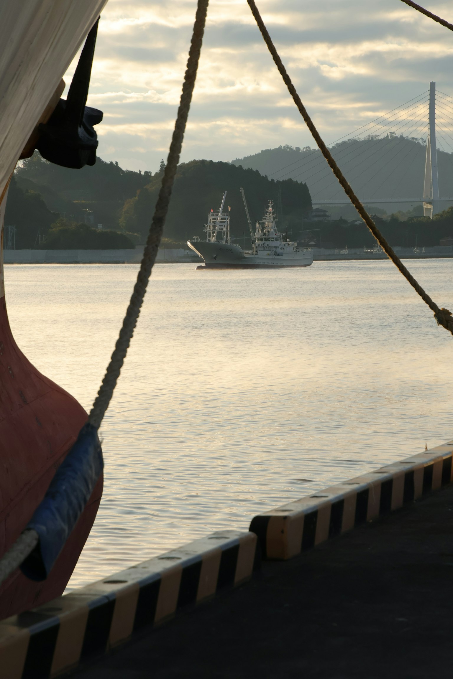 静かな水面に浮かぶ船と山々の背景