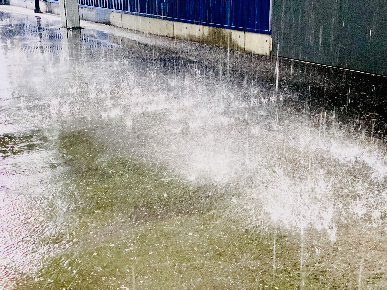 ภาพฝนตกทำให้เกิดน้ำขังบนพื้นผิวที่ปู