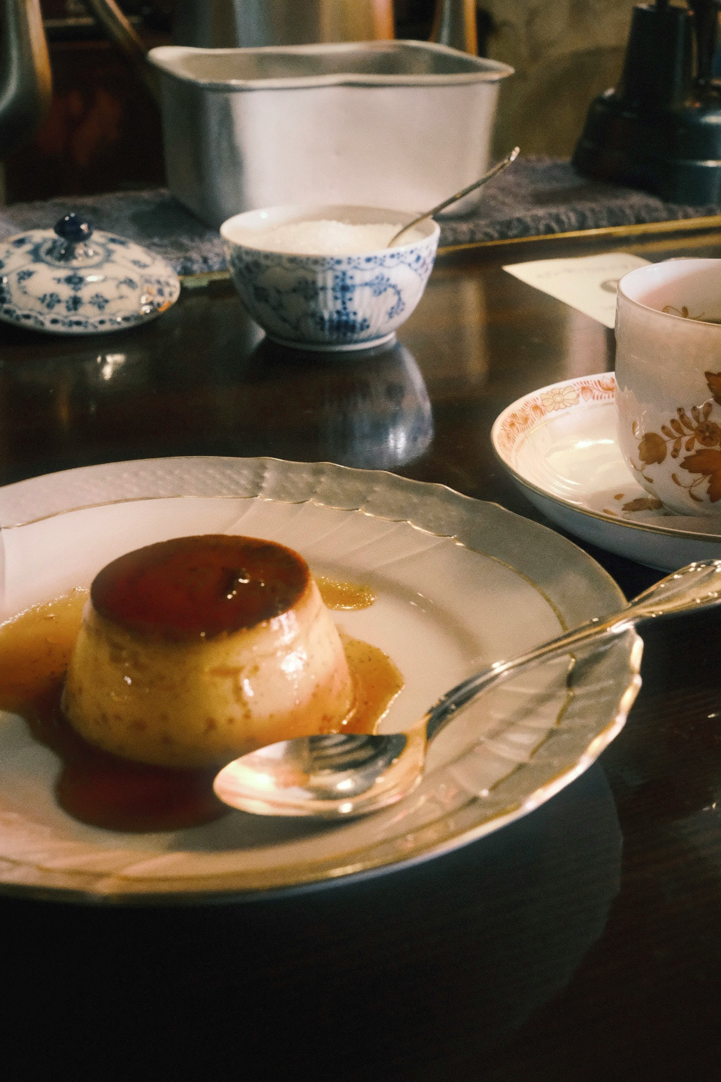 和食器の並ぶ食卓で湯気のある茶碗と皿