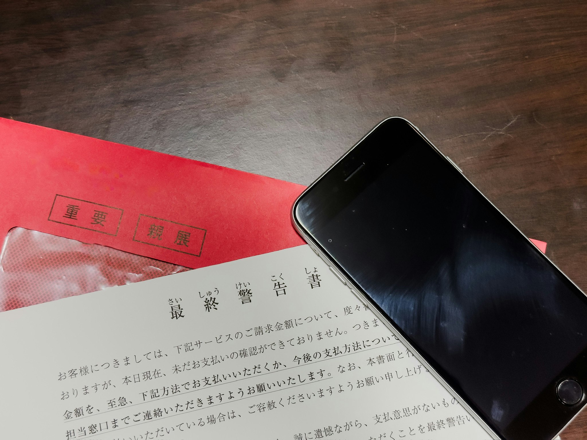 Tampak dekat amplop merah dan smartphone di atas dokumen