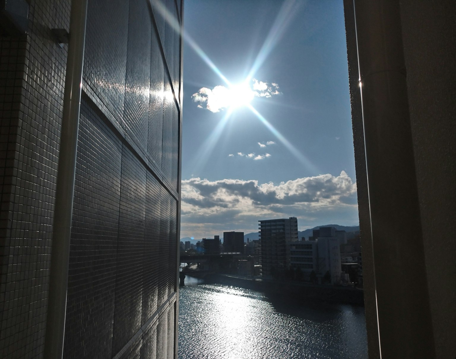 Vue lumineuse de la rivière et du soleil entre des immeubles de grande hauteur