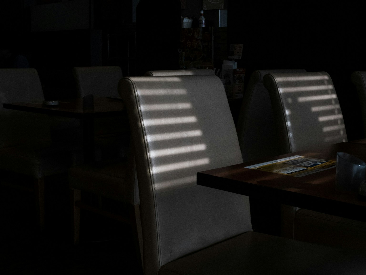 Scena di ristorante debolmente illuminata con sedie e tavolo