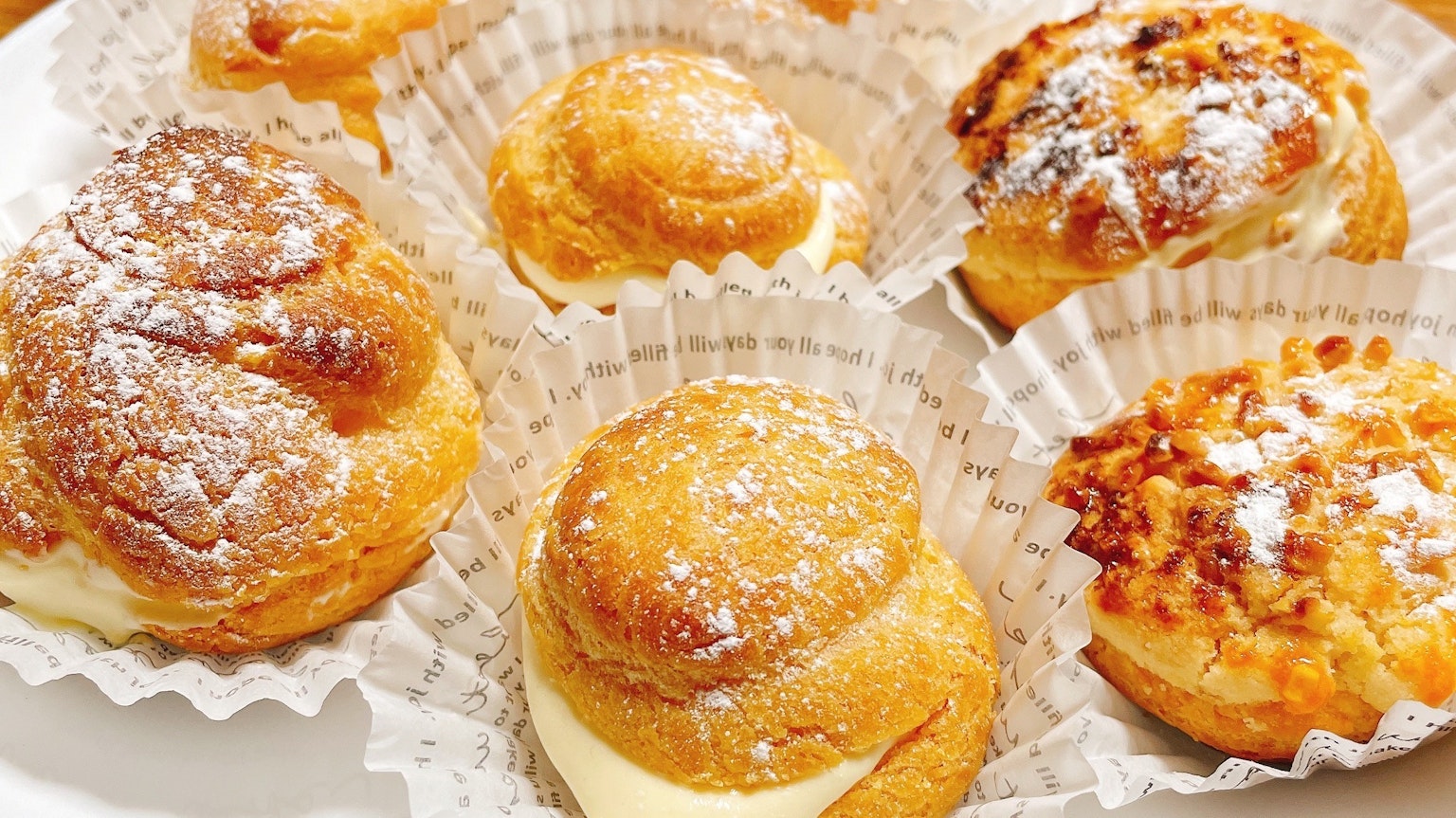 Assortiment de choux à la crème et de pâtisseries saupoudrées de sucre glace
