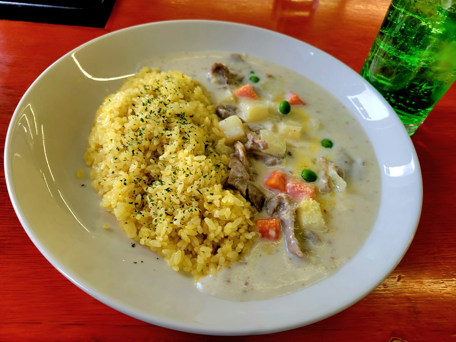 Plato de arroz amarillo con guiso cremoso de verduras y carne