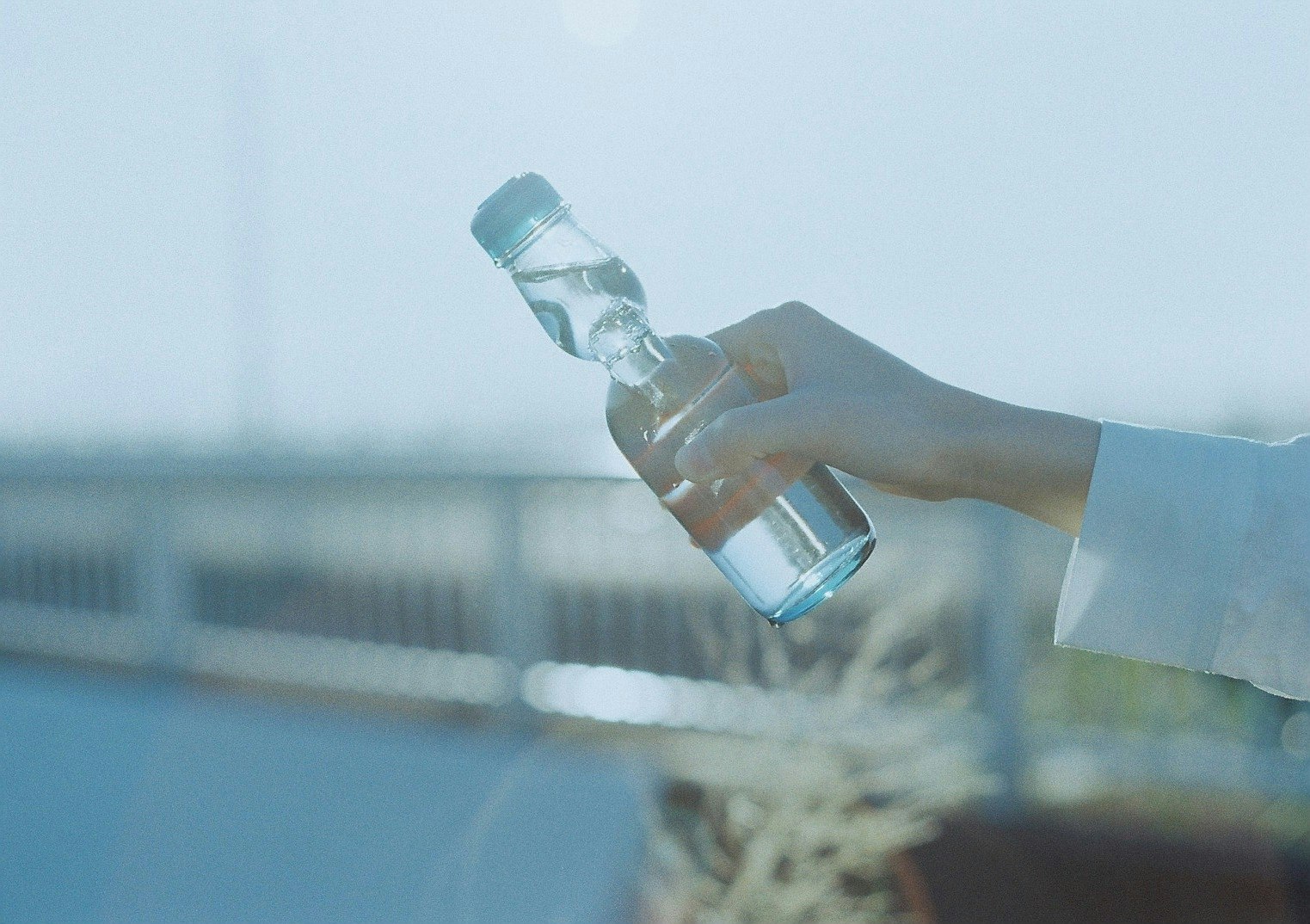 Nahaufnahme einer Person, die eine Wasserflasche ausgestreckt hält