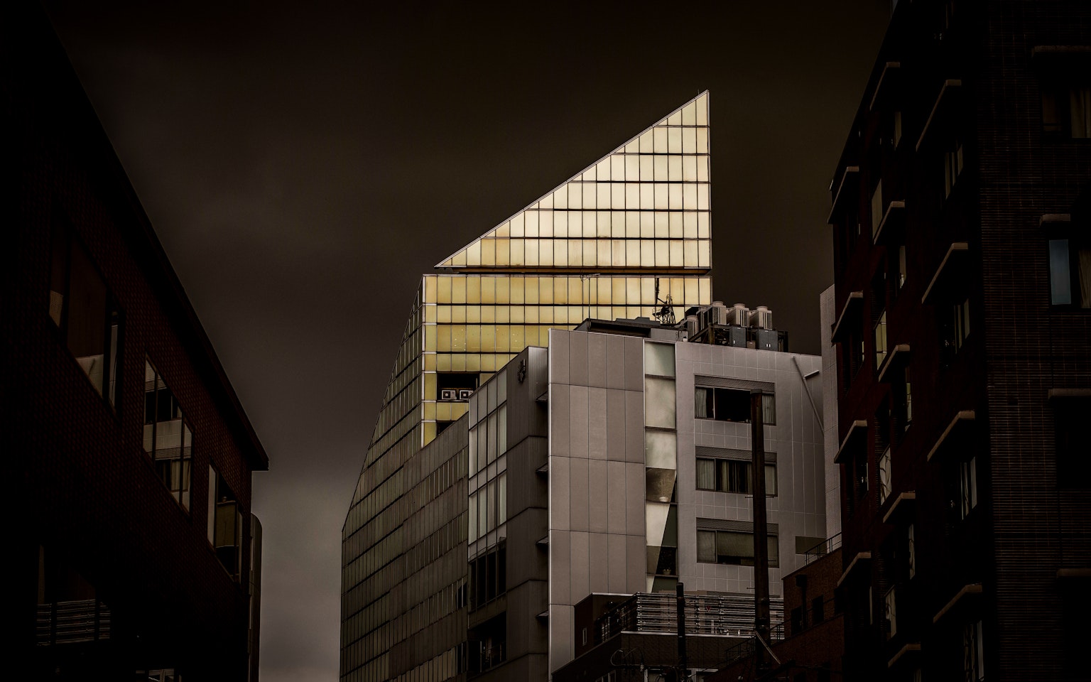 어두운 하늘 아래 날카로운 금색 지붕을 가진 현대 건물