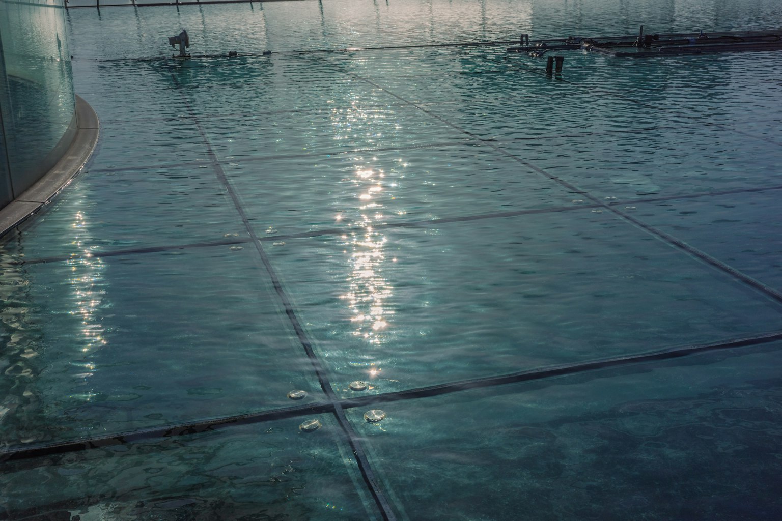 Innenansicht eines Pools mit heller Wasseroberfläche und Reflexionen
