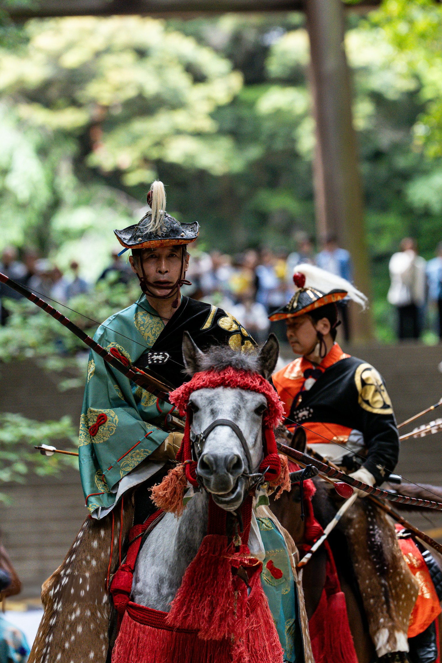 Traditional horse riders in elaborate costumes with spectators in the background
