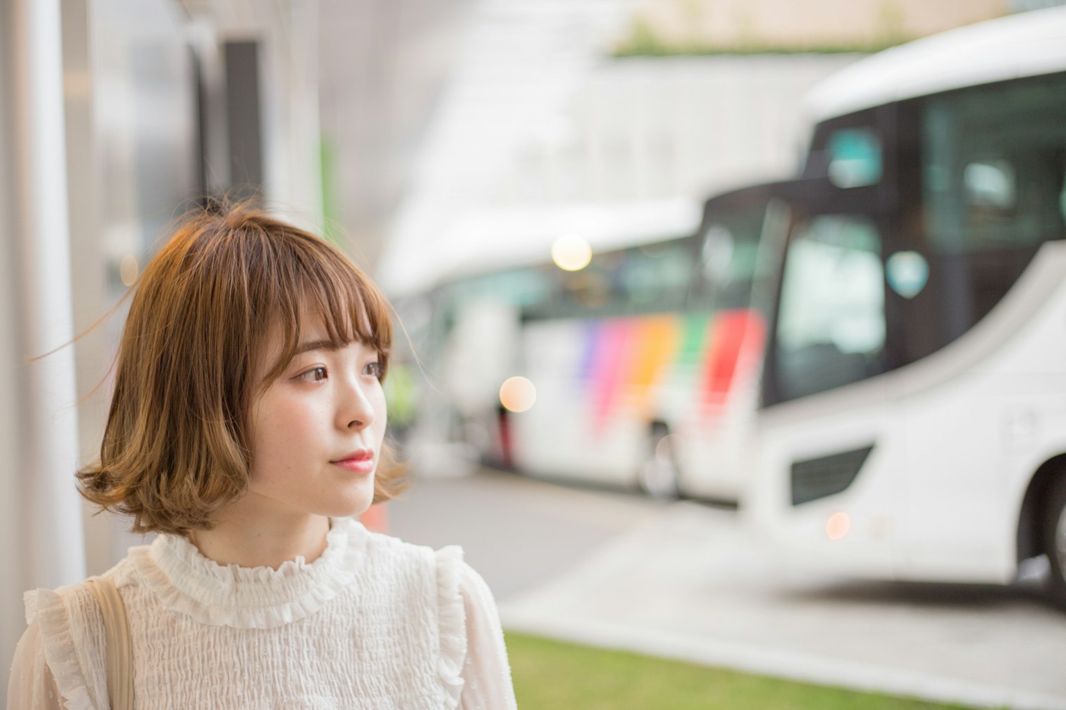 Potret wanita yang berpikir dengan bus putih di latar belakang