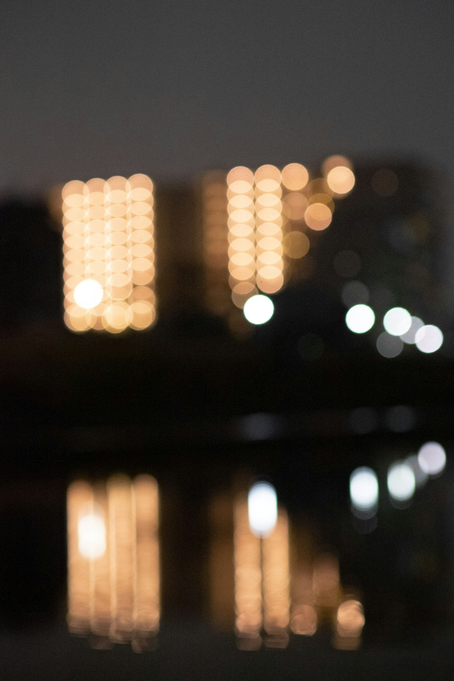 模糊的夜间城市景观和水面上的灯光倒影