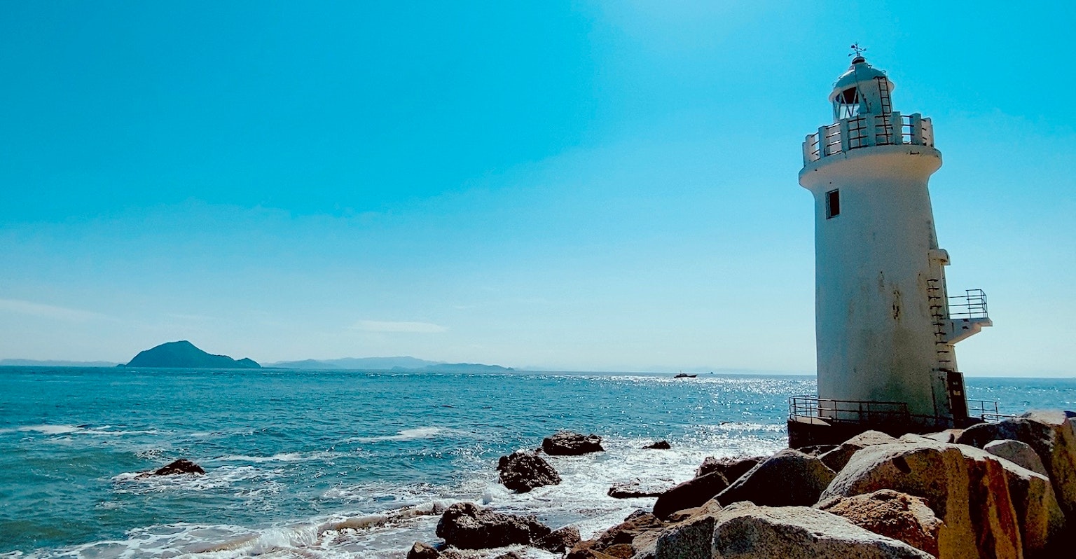 Vista panoramica di un faro al mare sotto un cielo blu