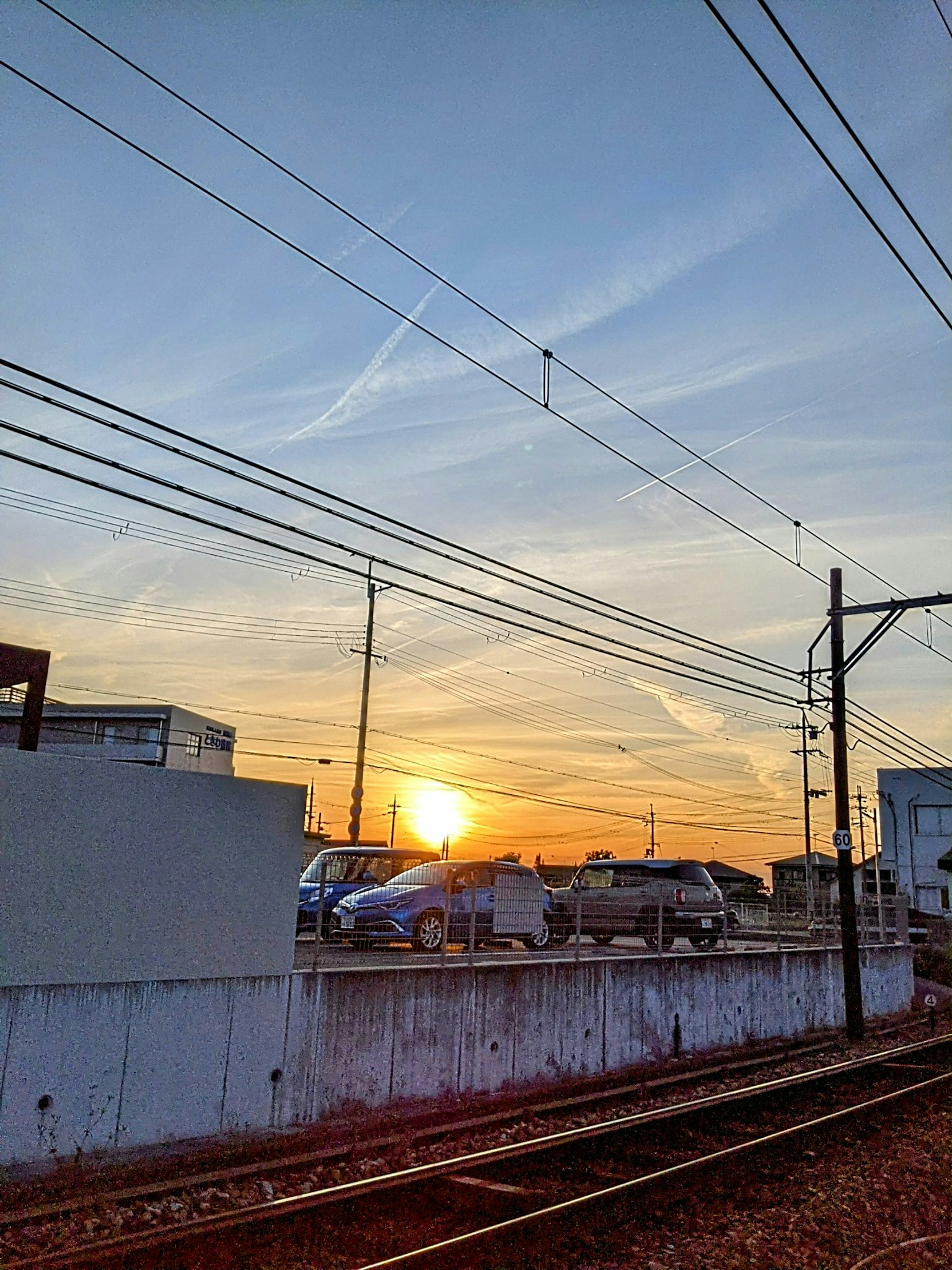 Vue du coucher de soleil avec des voies ferrées et des bâtiments visibles