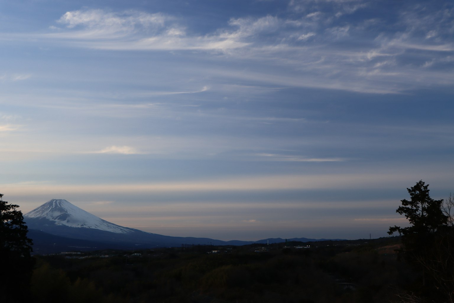 Monte innevato sotto un cielo blu con nuvole