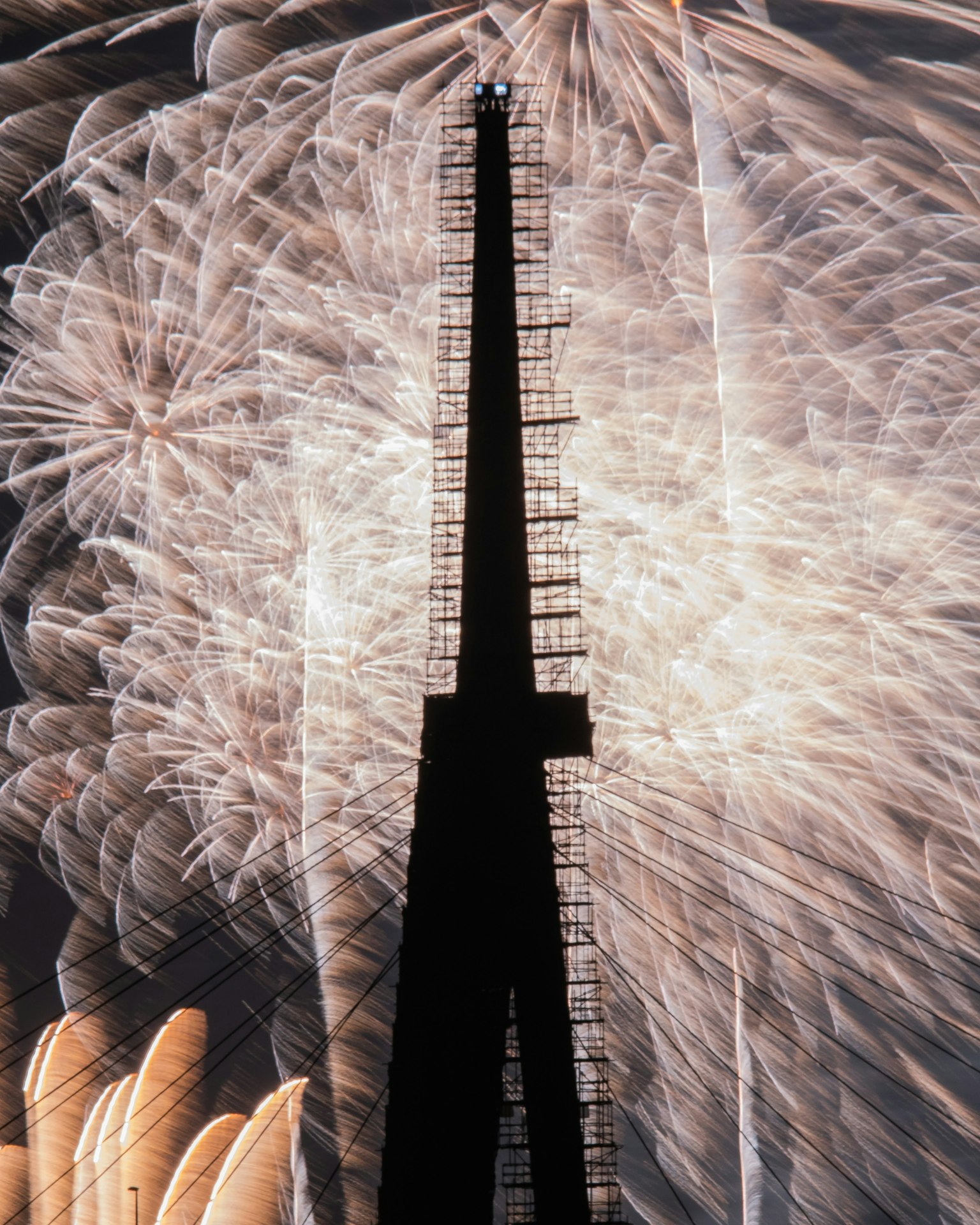 Silhouette of the Eiffel Tower against a backdrop of fireworks