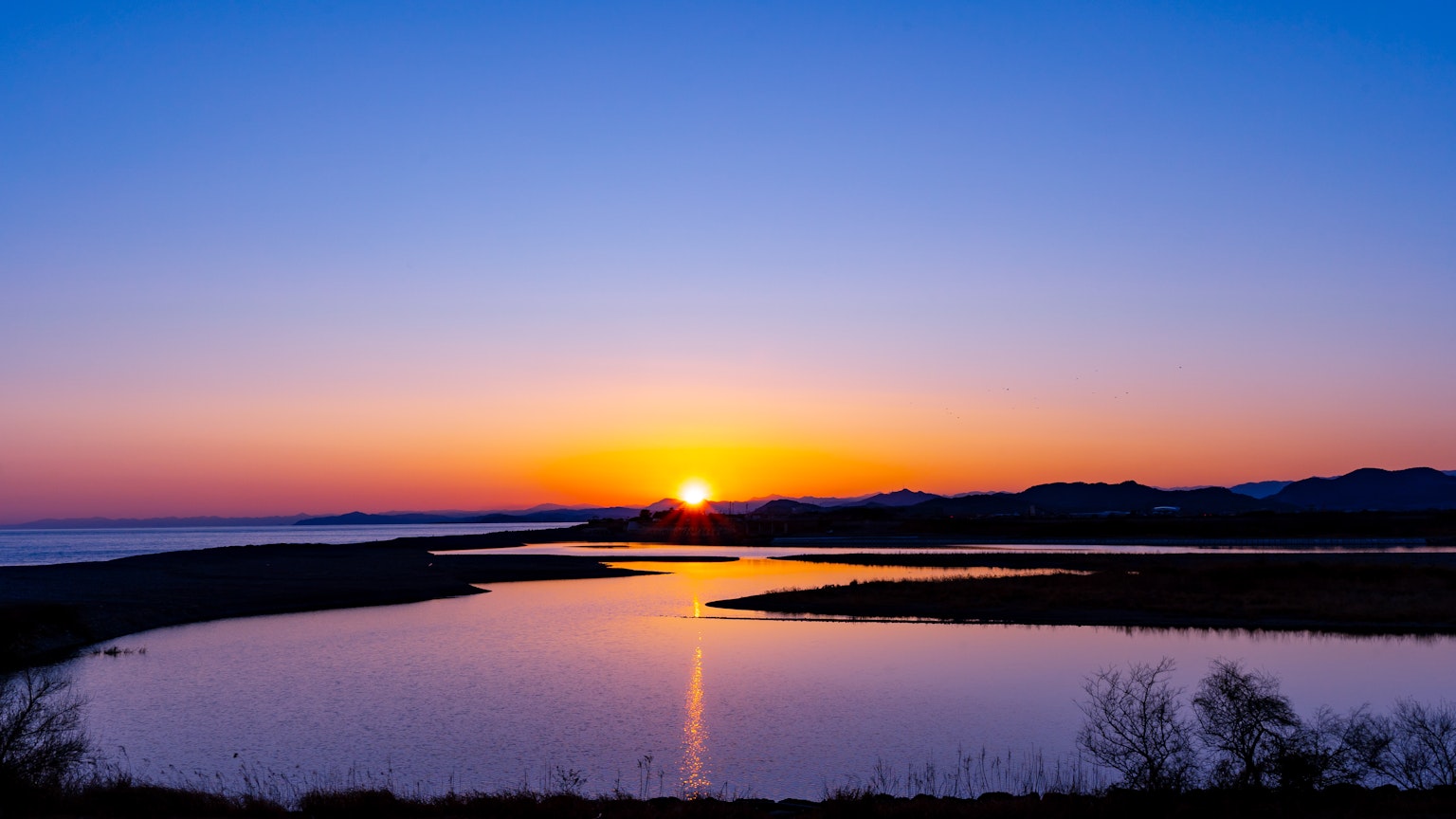 Vista panoramica di un lago al tramonto con colori vivaci