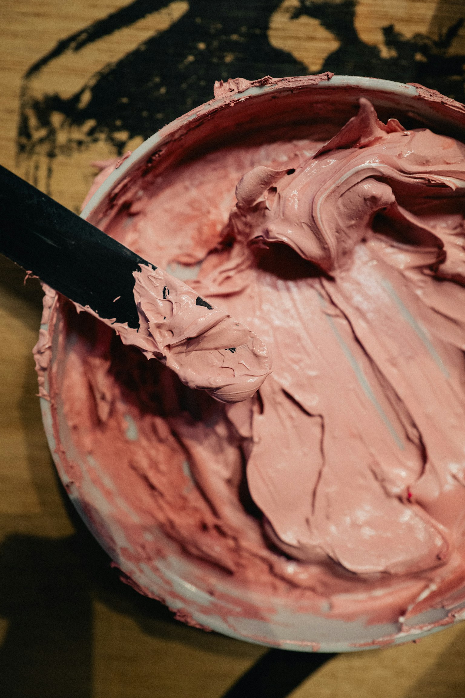 ピンク色のクリームが入った容器とスパチュラ