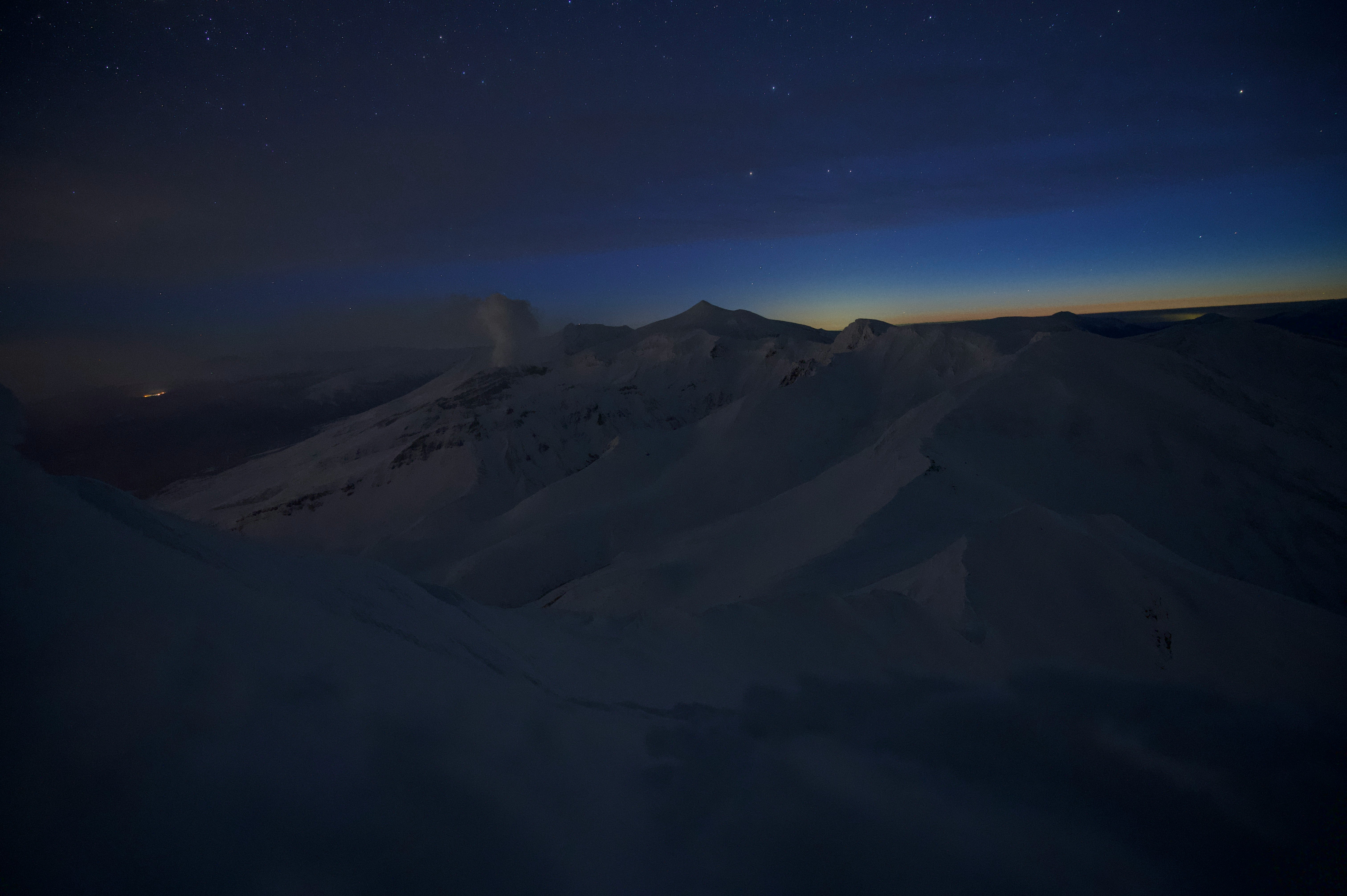 夜明け前の山稜に広がる星空と薄明の空