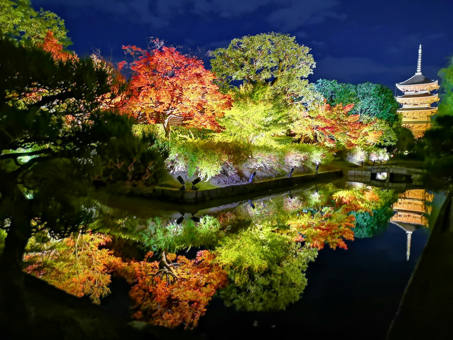 Magnifique feuillage d'automne se reflétant dans un étang sous le ciel nocturne avec une pagode japonaise