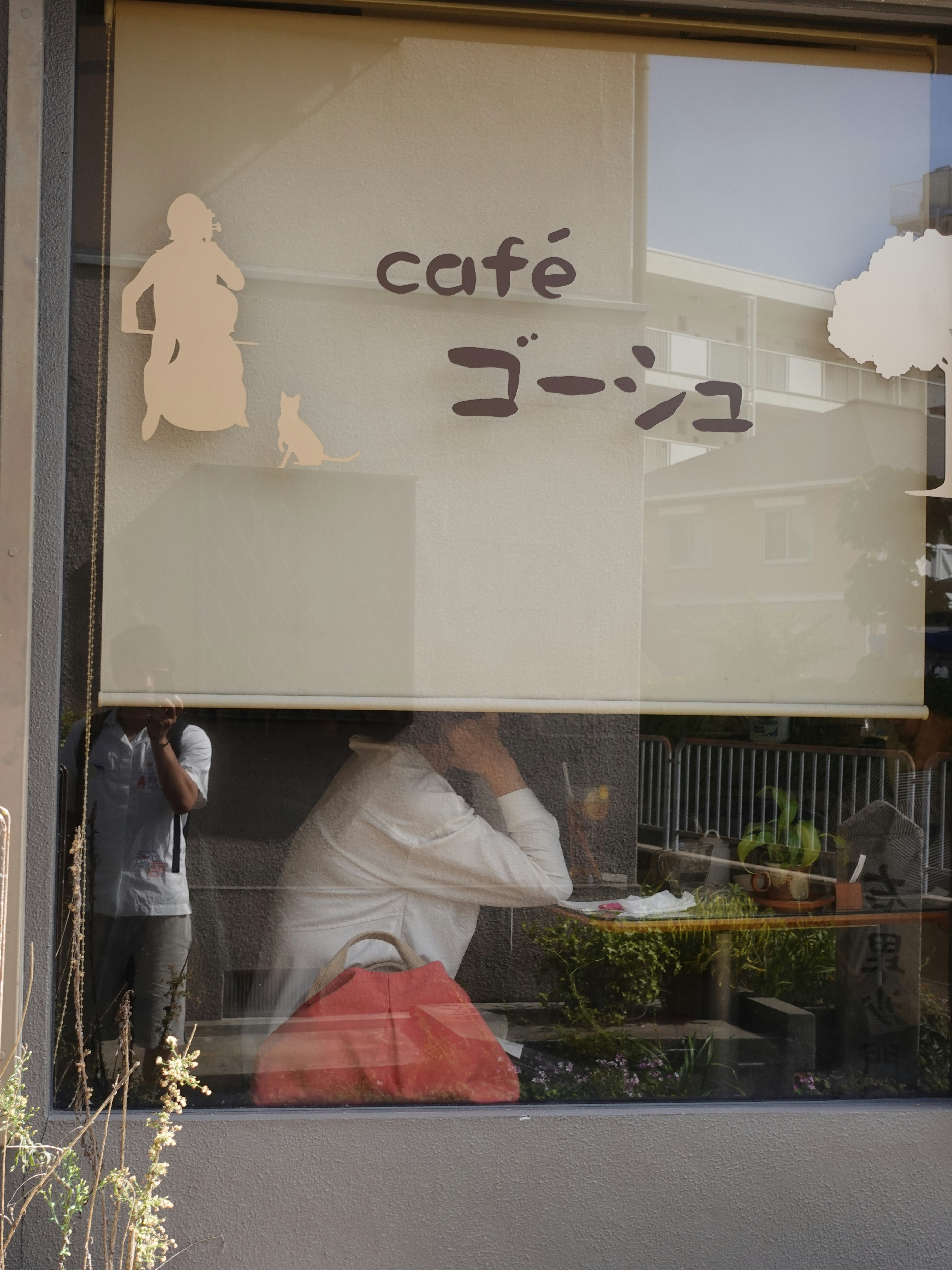 「café ゴーシュ」の看板が映る窓越しの店内