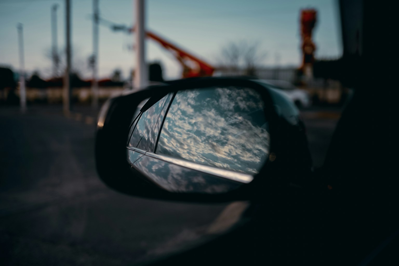 Reflejo del cielo azul y las nubes en un espejo lateral de coche