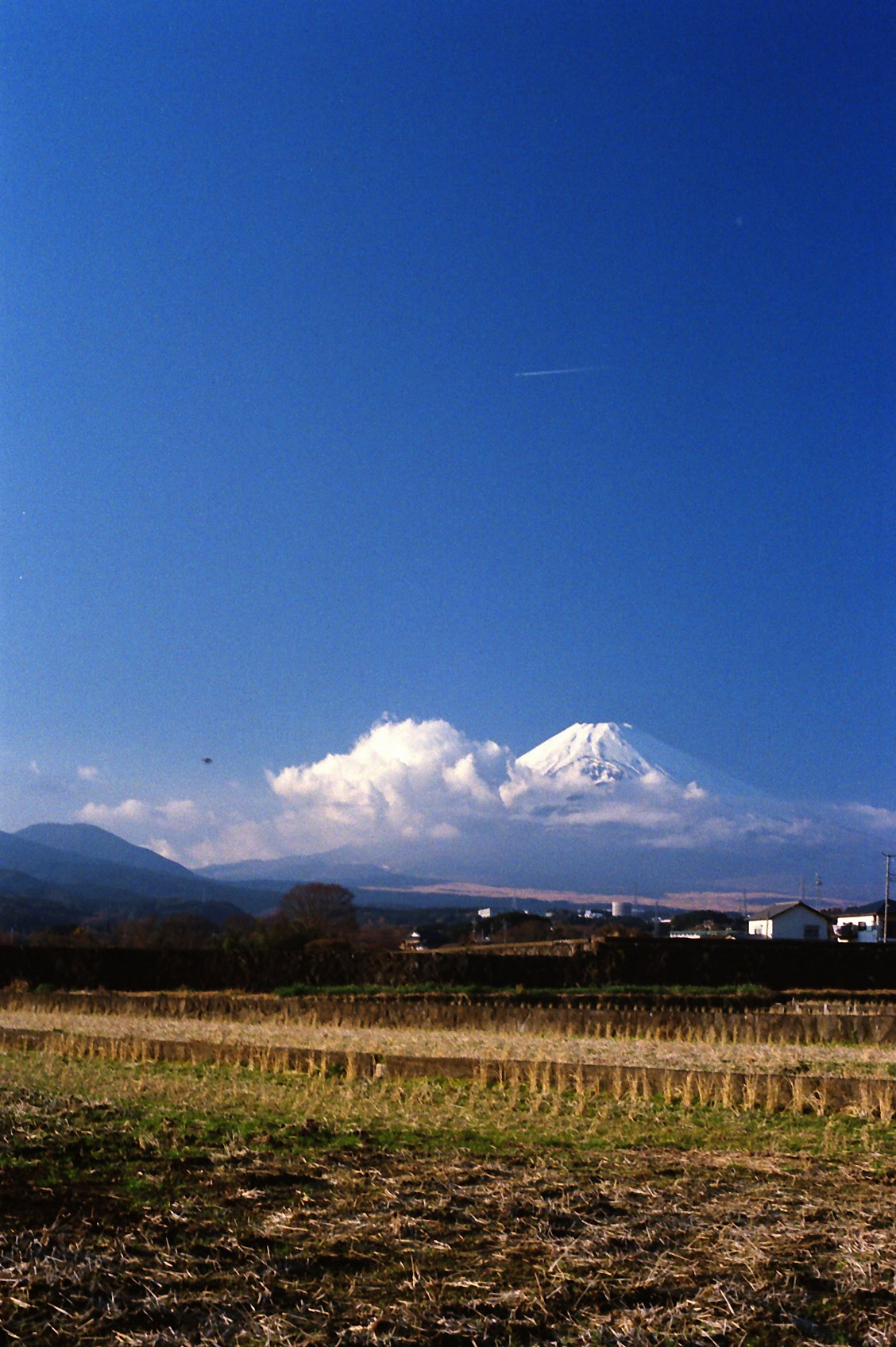 畑と山並み、青空に浮かぶ雲と雪をかぶった山