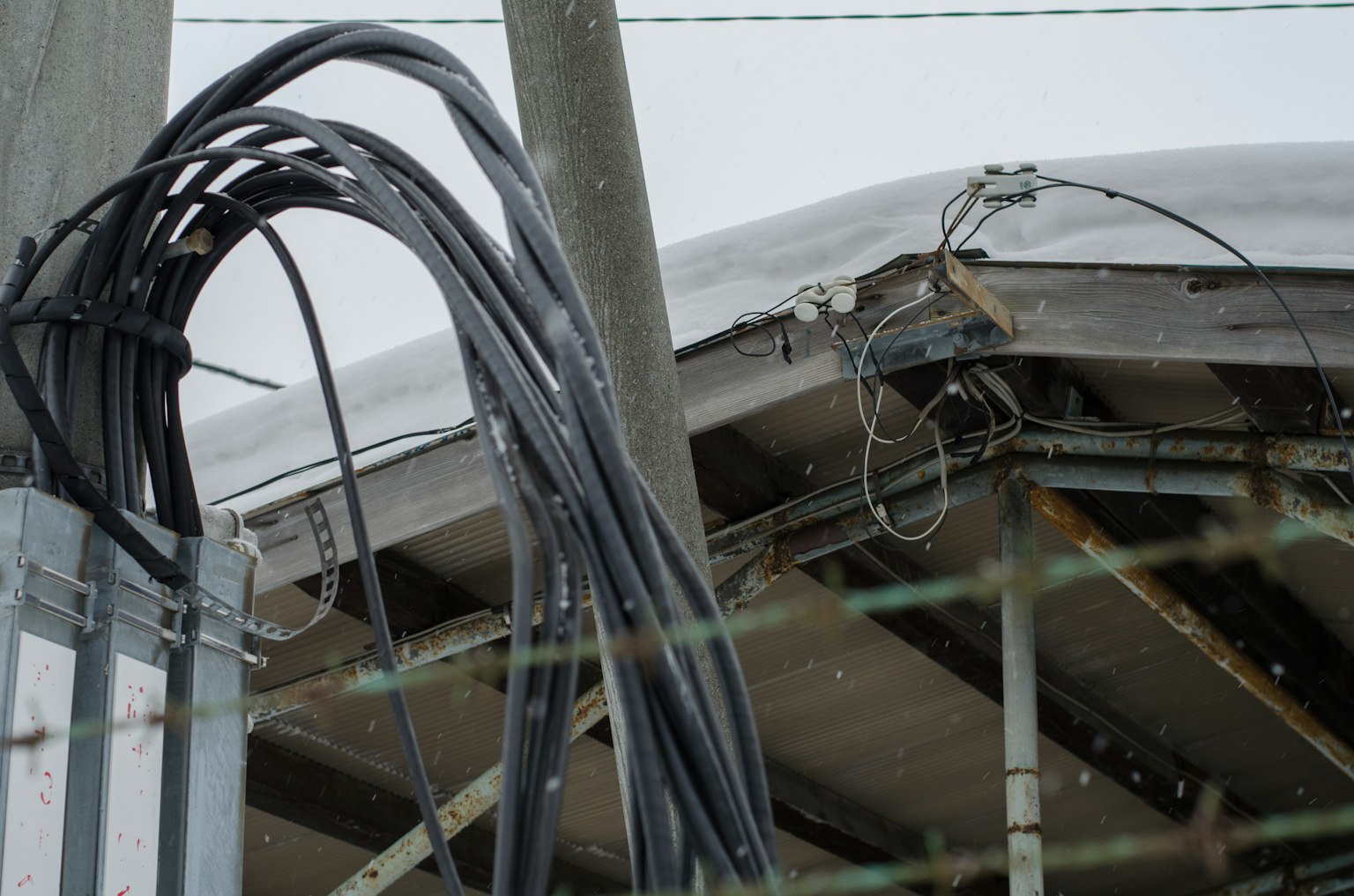 Part of a building roof with hanging wires
