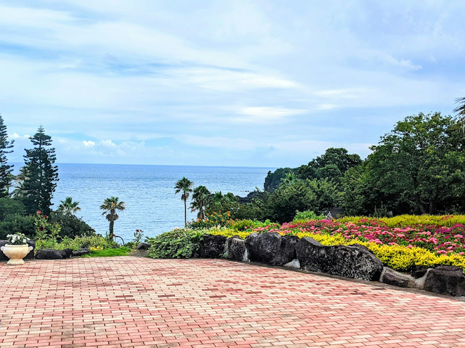 Panoramablick auf einen Garten mit Blumen und Ozean im Hintergrund