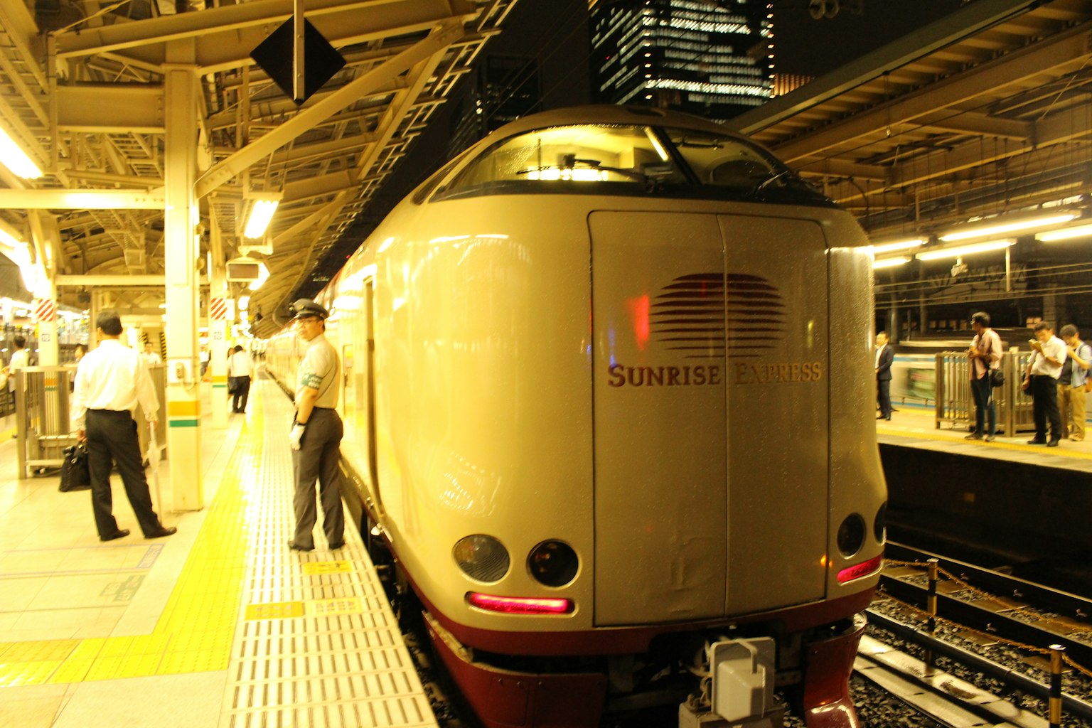 Tàu Shinkansen vào ban đêm với hành khách trên sân ga