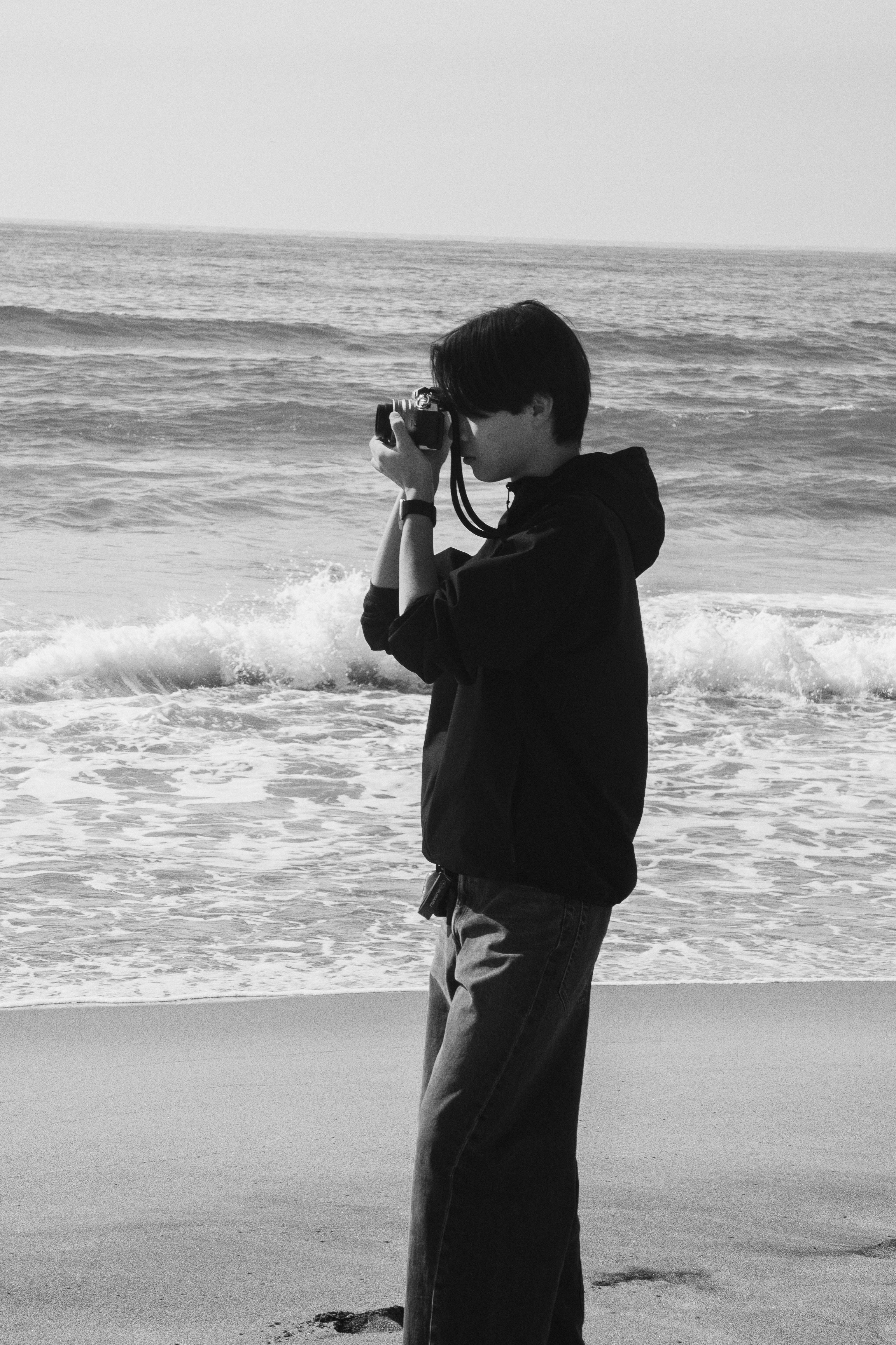Padre o madre sosteniendo a un niño en la playa, vista de espaldas