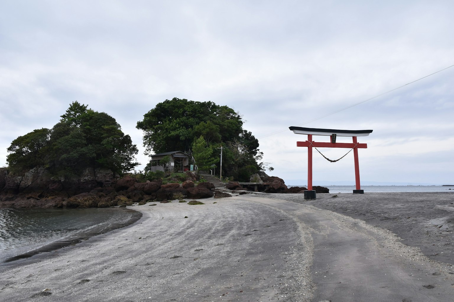 Scena costiera con un torii rosso e un'isola