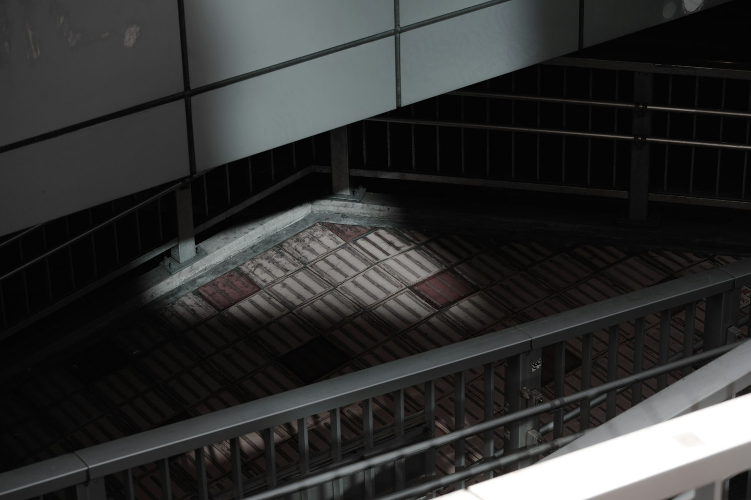 Photographie d'un escalier avec rampes et reflets de lumière