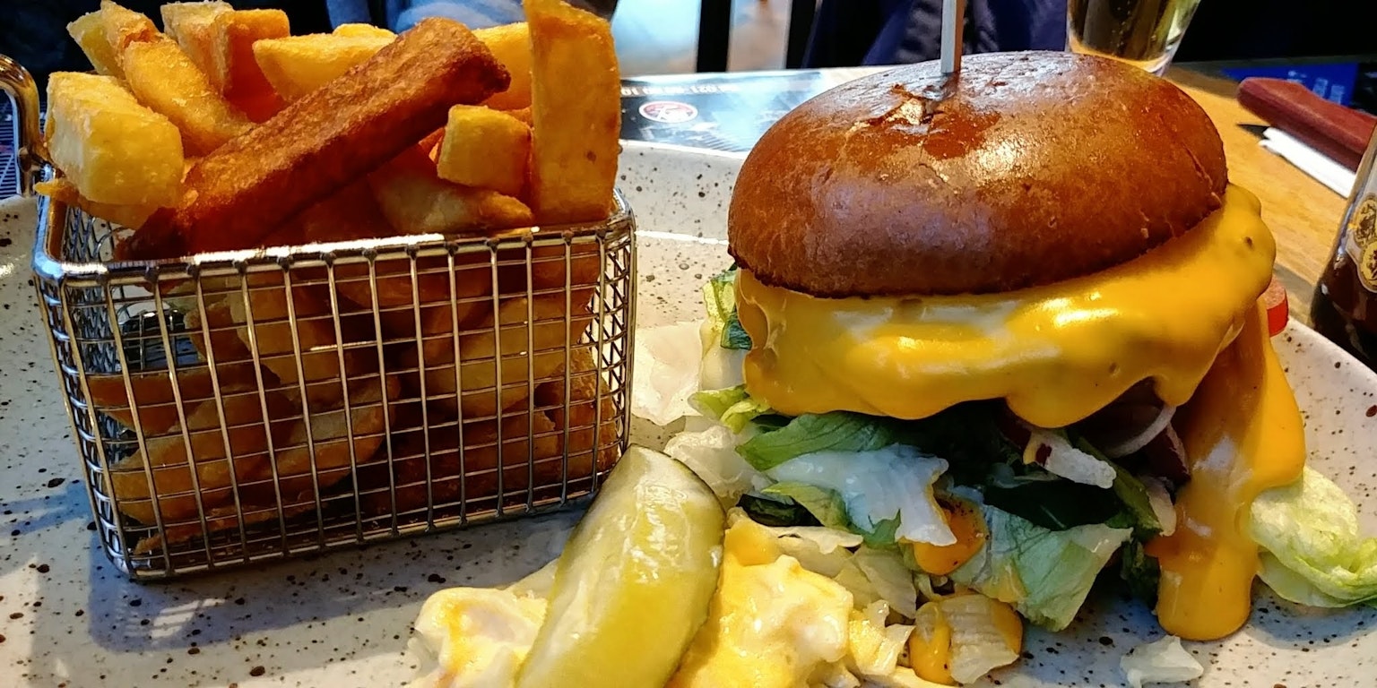 Hamburguesa jugosa con queso derretido y papas fritas crujientes