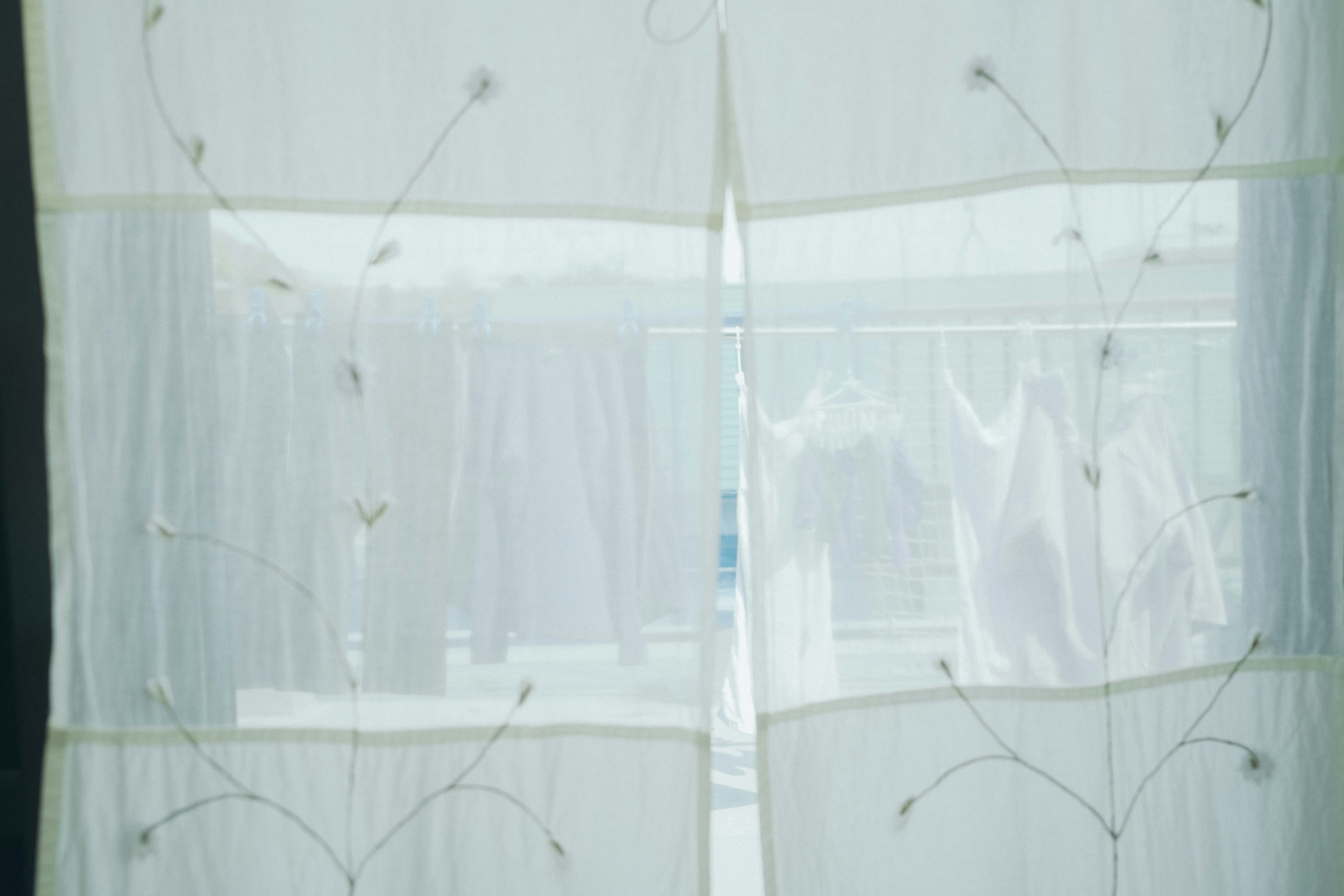 白いカーテンが窓を覆っている透け感のあるデザイン