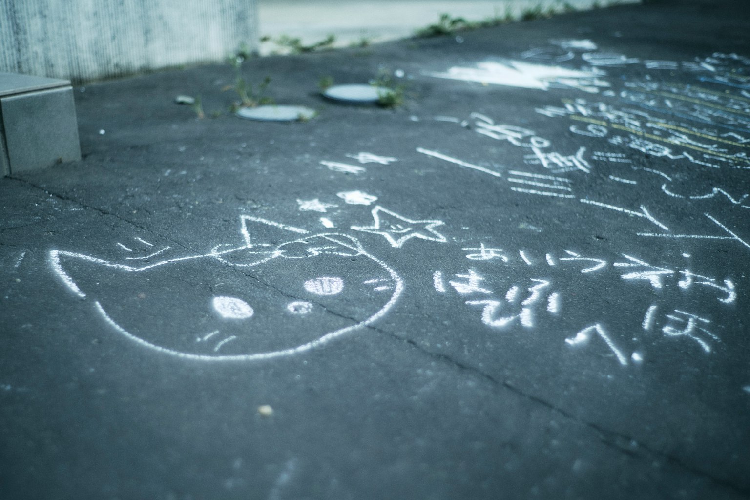 Dibujo a tiza de la cara de un gato y una estrella en el suelo graffiti de tiza blanca