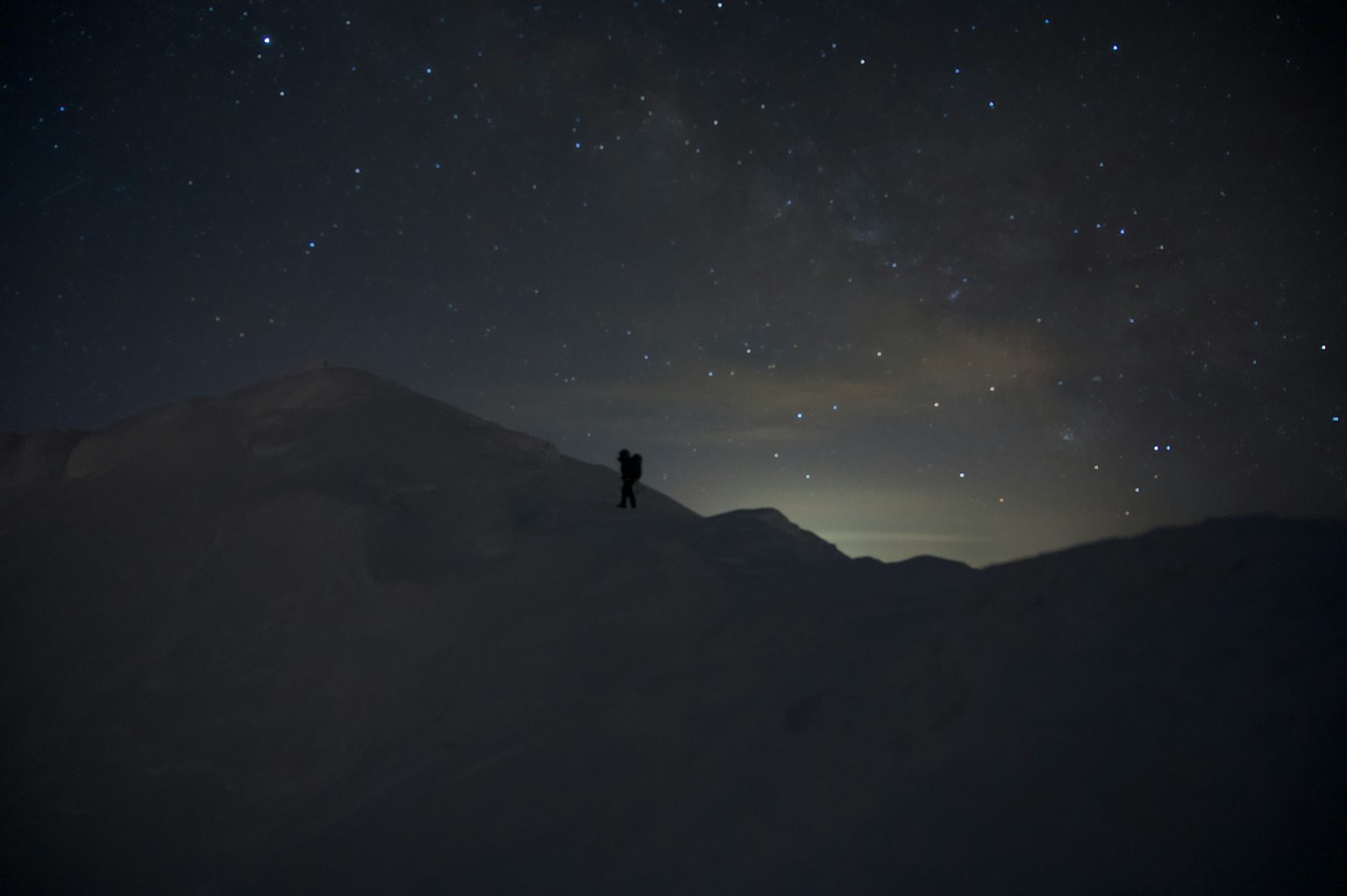雪山上星空下的登山者輪廓