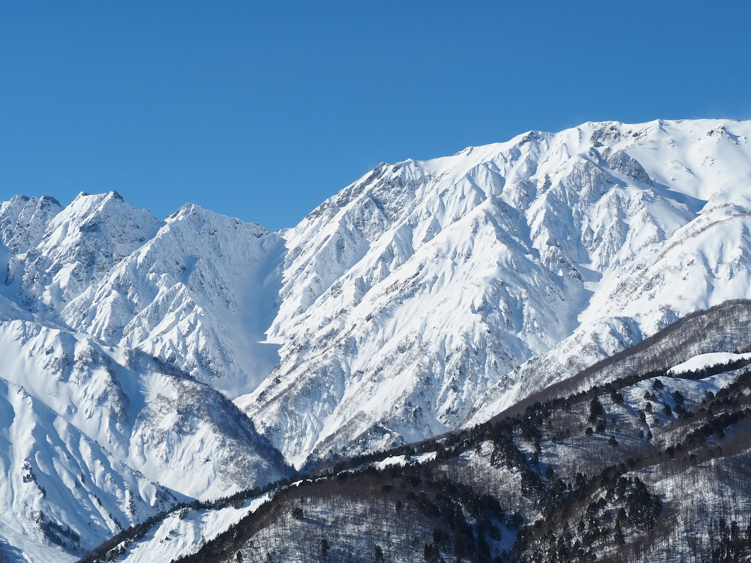 Montagnes enneigées sous un ciel bleu clair